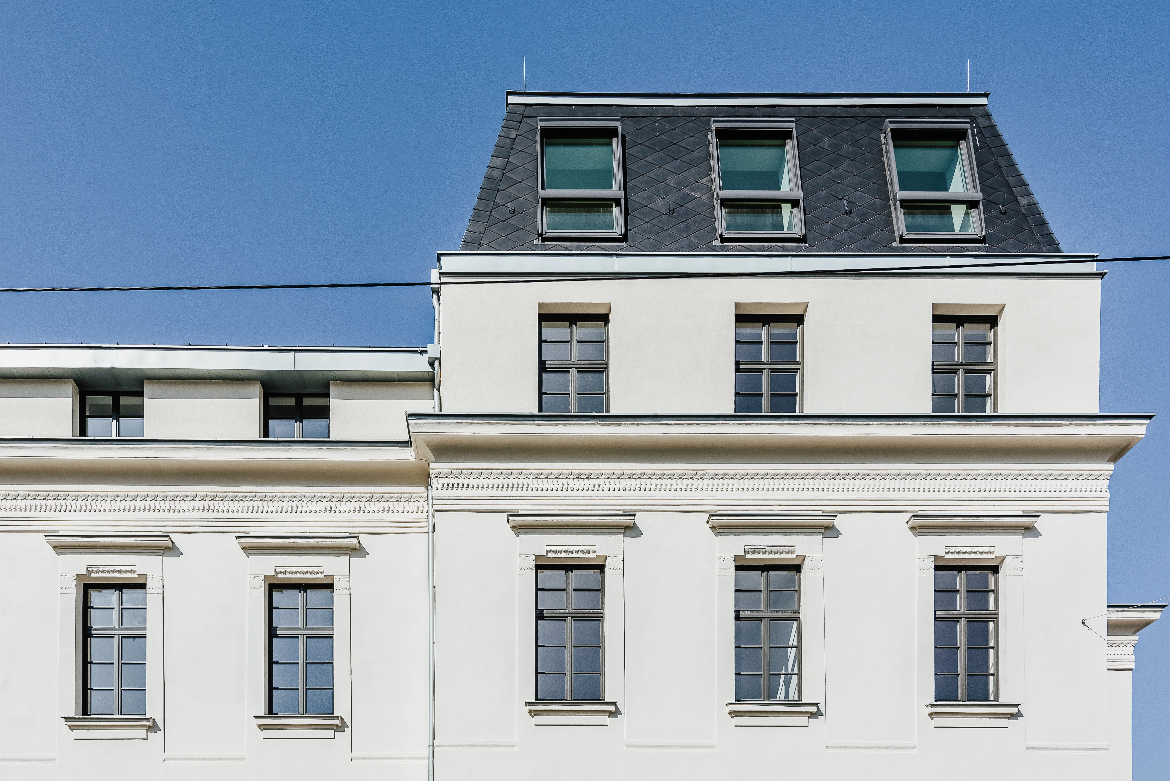 Hausfront mit Fenstern ab oberen Stockwerken