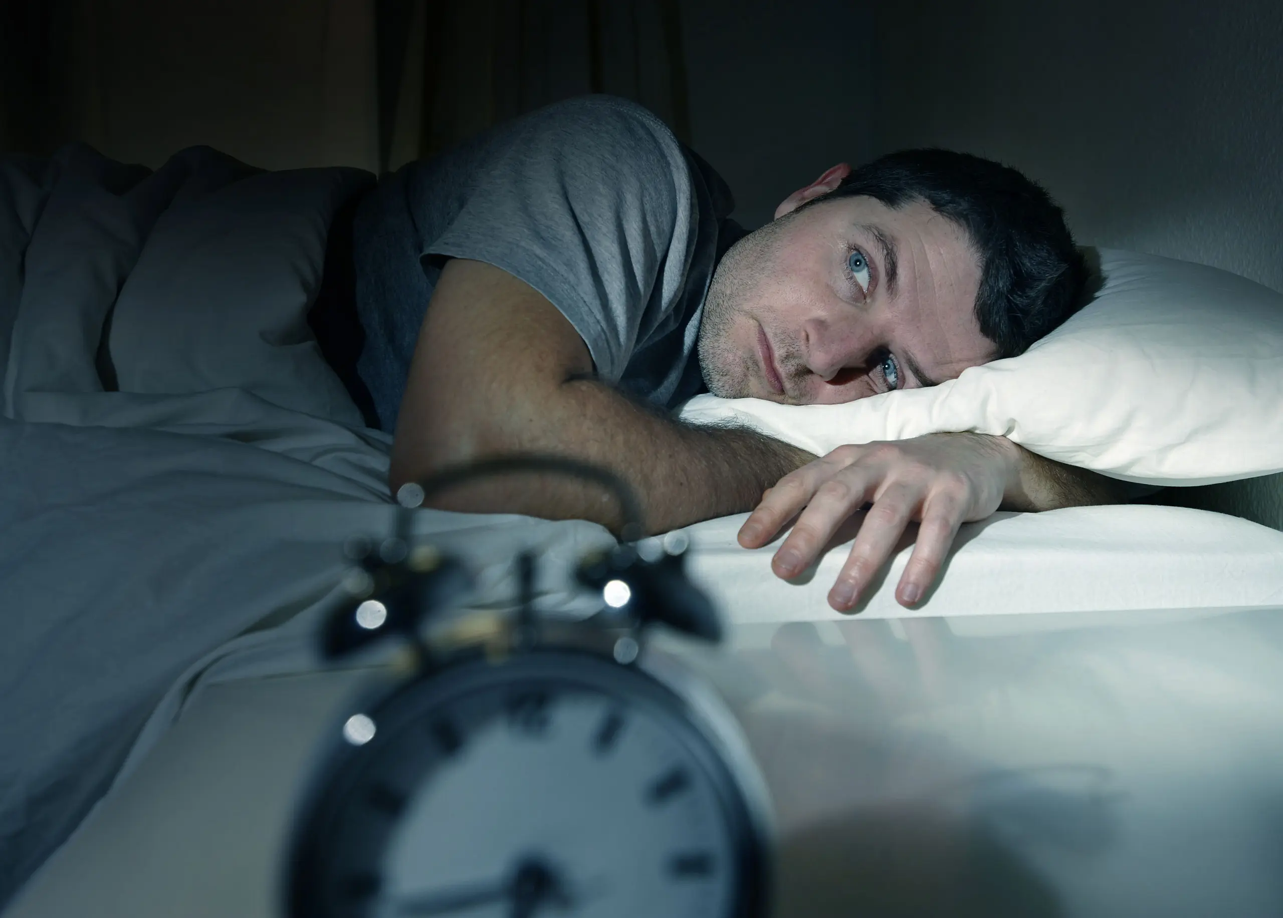 Schlafloser Mann im Bett