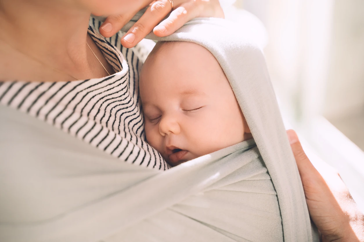 Baby, das in einem Tragetuch schläft