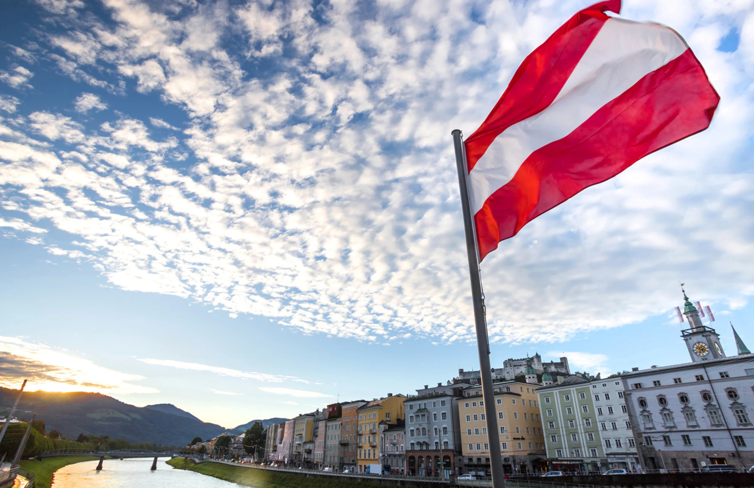 Eine österreichische Fahne weht über historischem Salzburger Stadtbild.