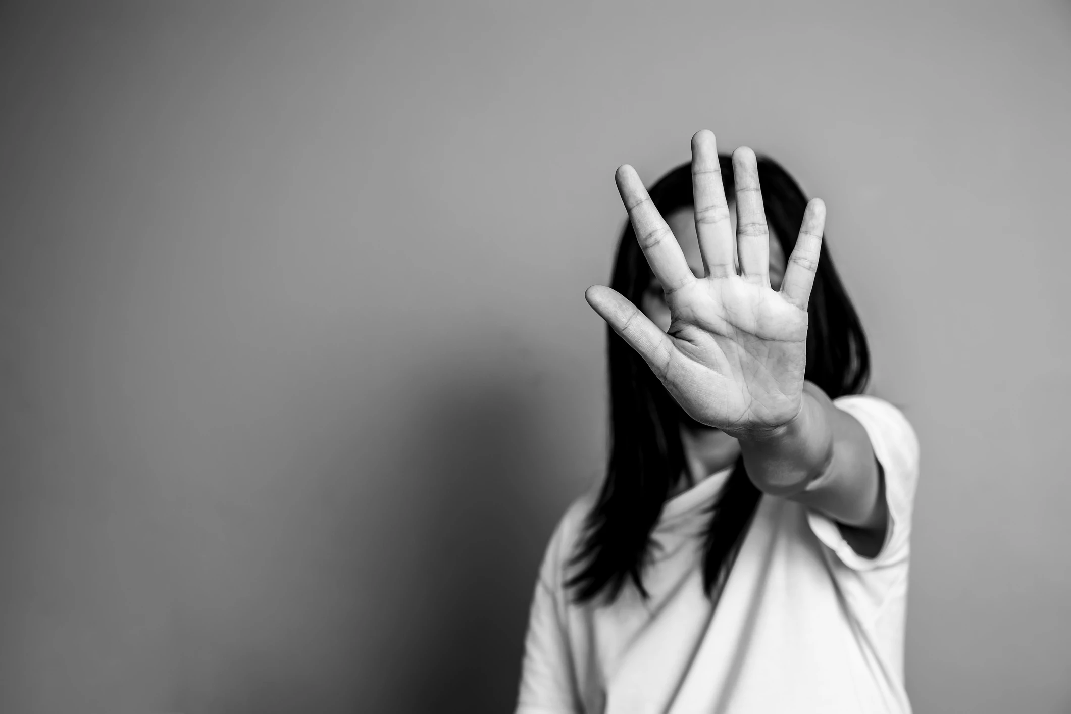 Frau mit erhobener Hand vor Gesicht