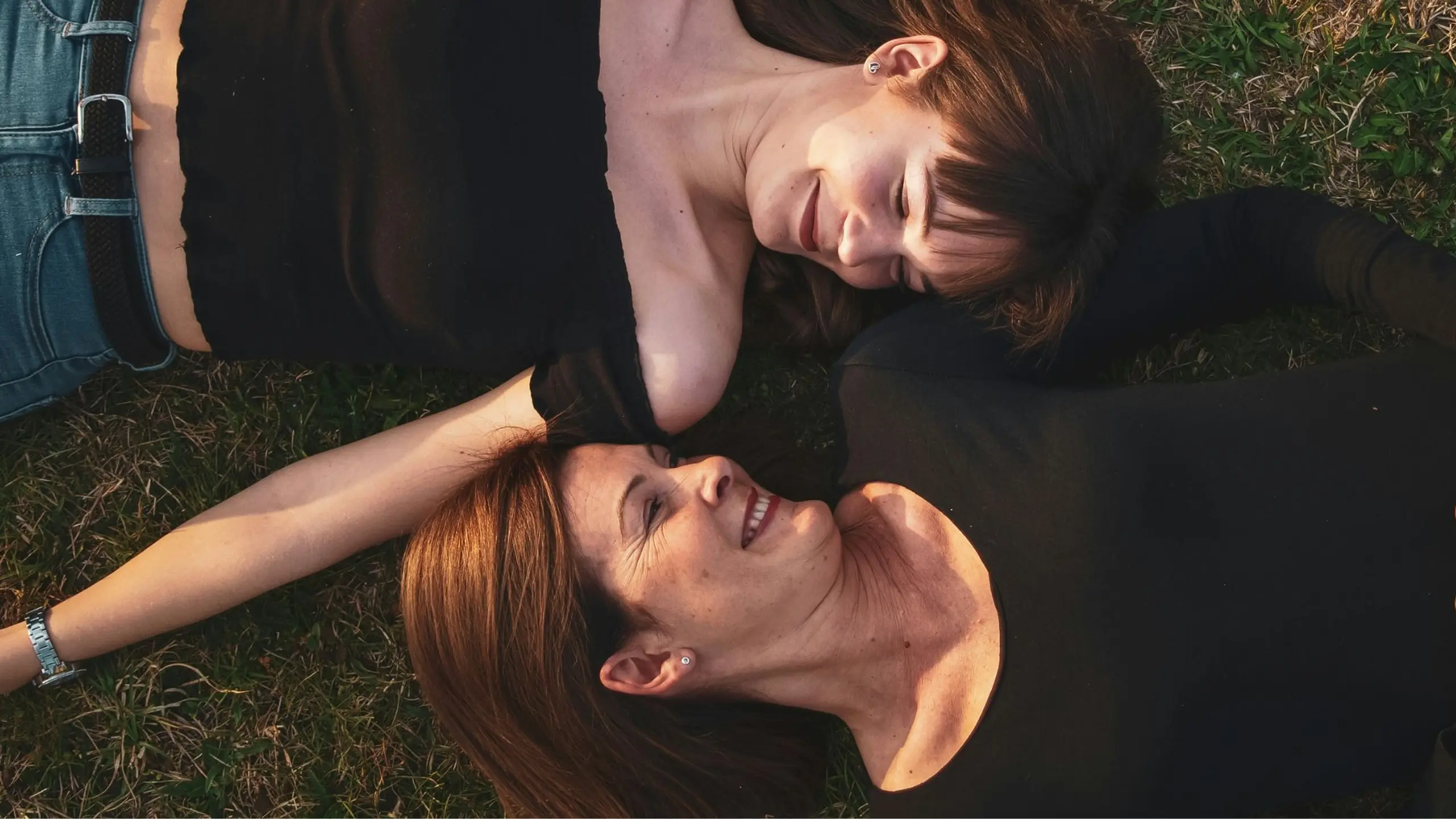 Mutter und Tochter liegen im Gras