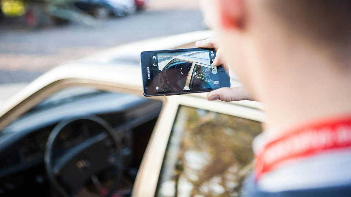 Display eines Smartphones mit dem der Mercedes W201 190D gerade fotografiert wird.