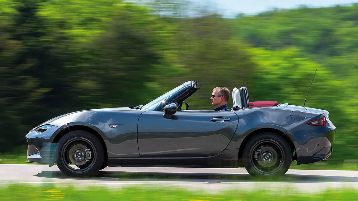 Ein mit Sonnenbrille ausgestatteter Autofahrer in einem Cabrio.