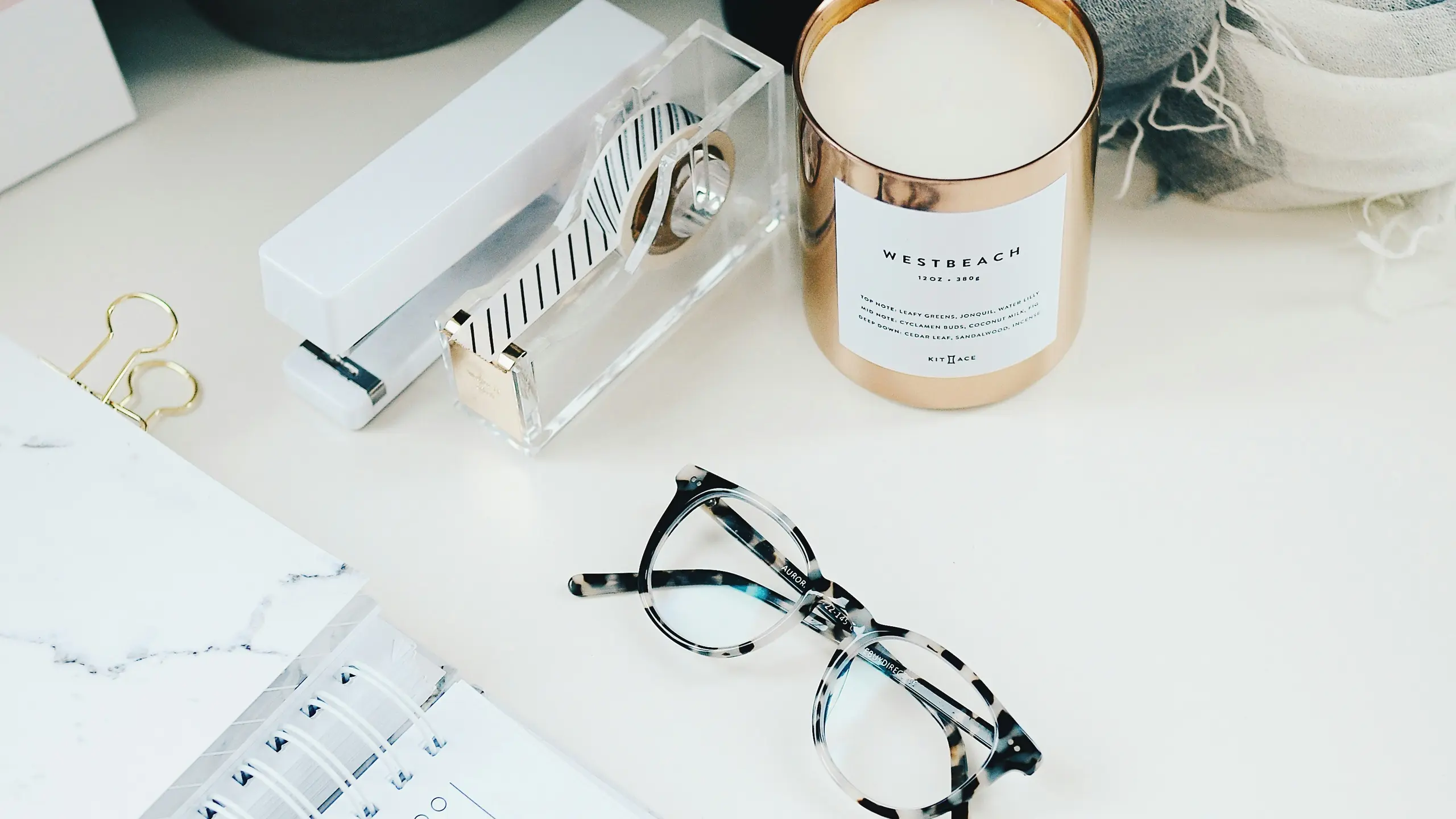 Schreibtisch mit Planer, Kerze und Brille