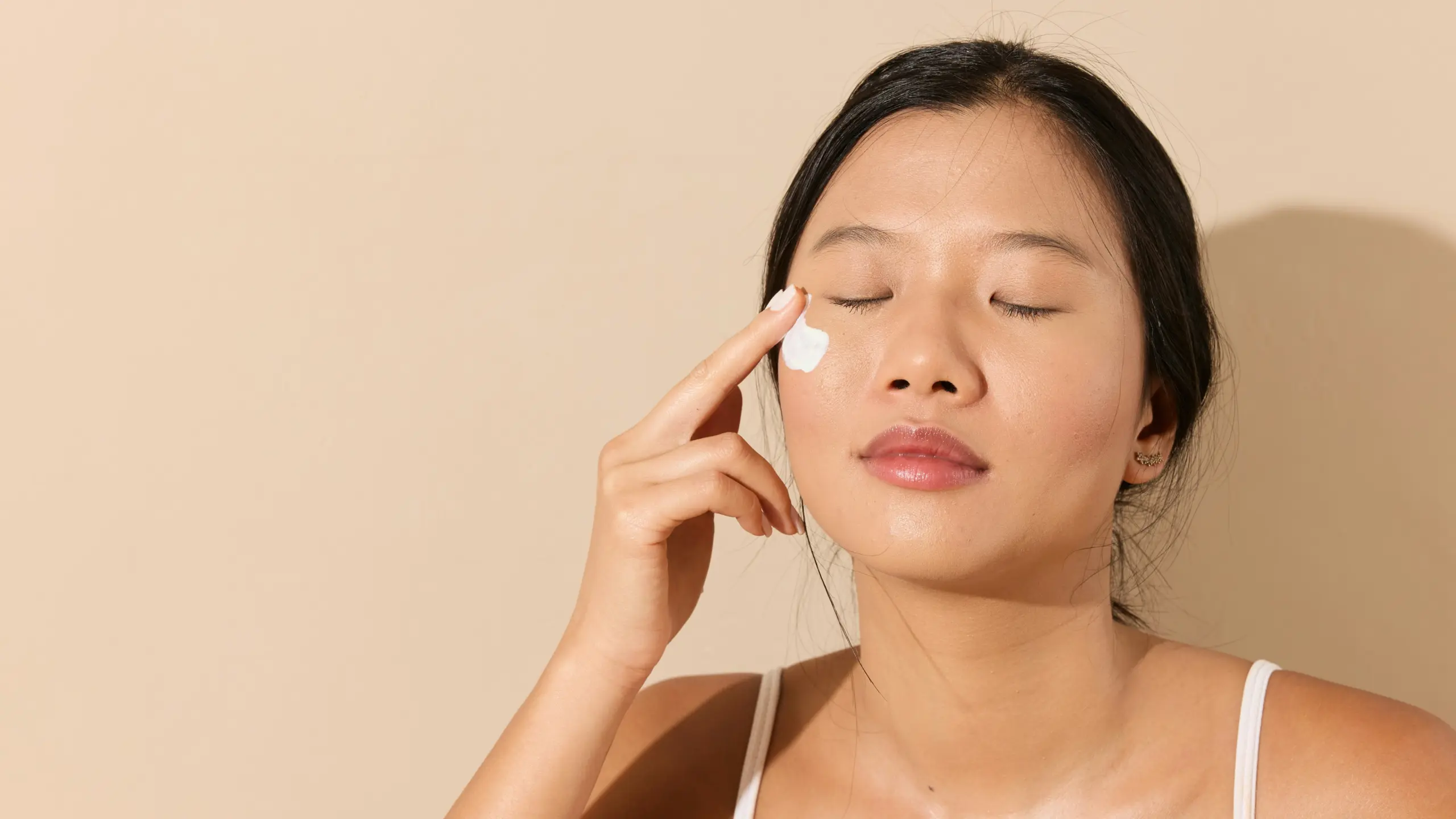 Frau cremt sich das Gesicht ein