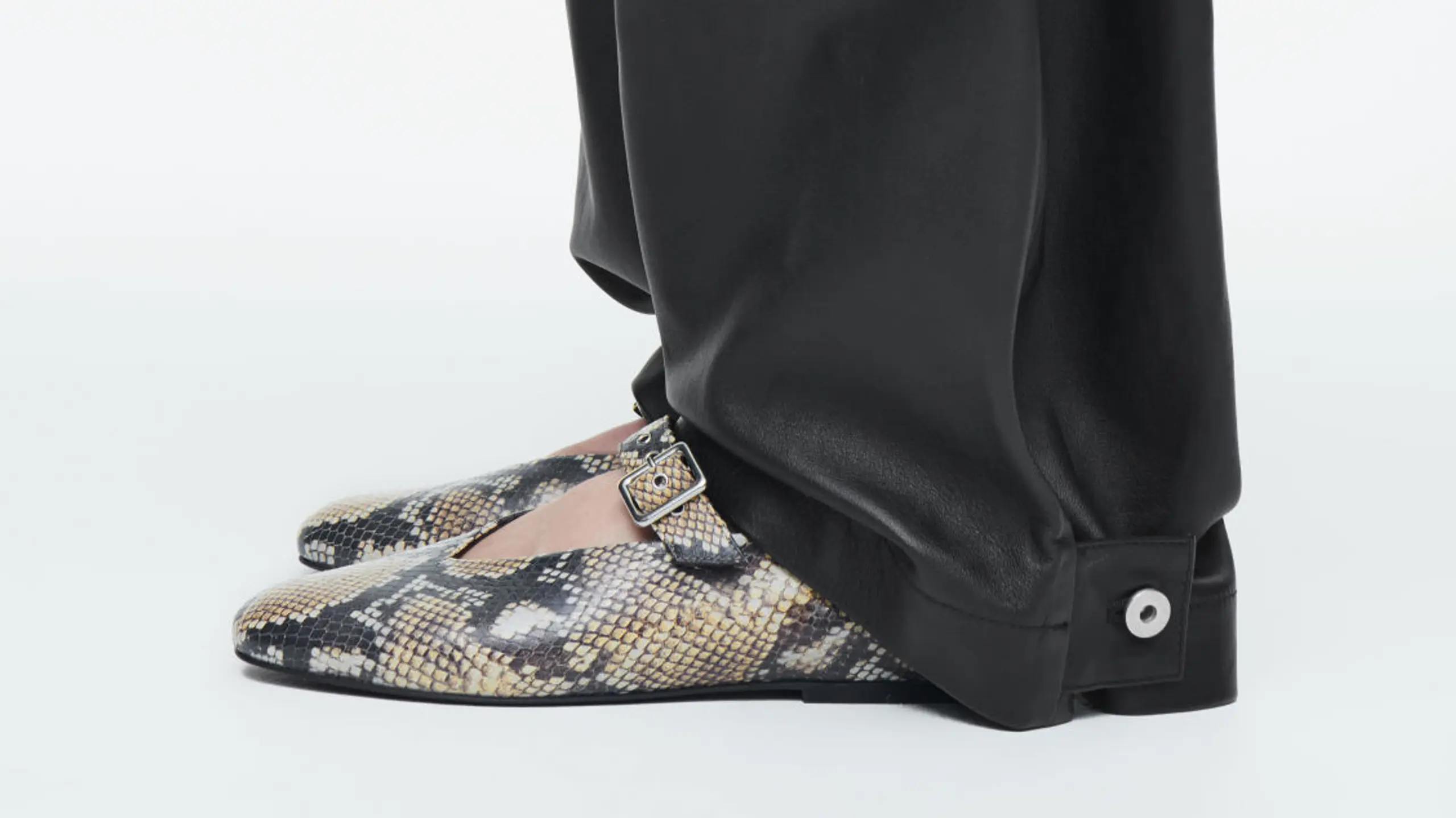 Closeup von schwarzer Hose und Snakeskin-Ballerina