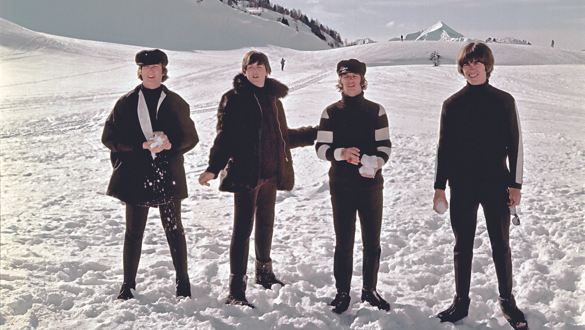 Die Beatles (John Lennon, Paul McCartney, Ringo Starr, George Harrison) posieren 1965 in Obertauern, Österreich, im Schnee während der Dreharbeiten zu ihrem Film „HELP!“. Ein unvergessliches Foto aus den 60er Jahren.
