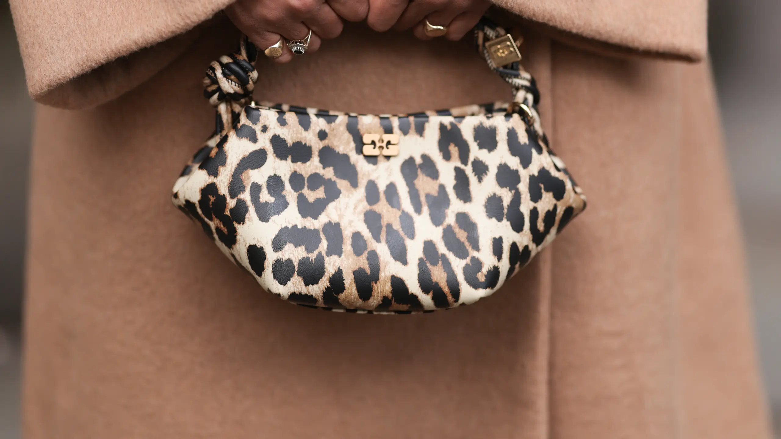 Frau Mit braunem Mantel und Leo-Tasche