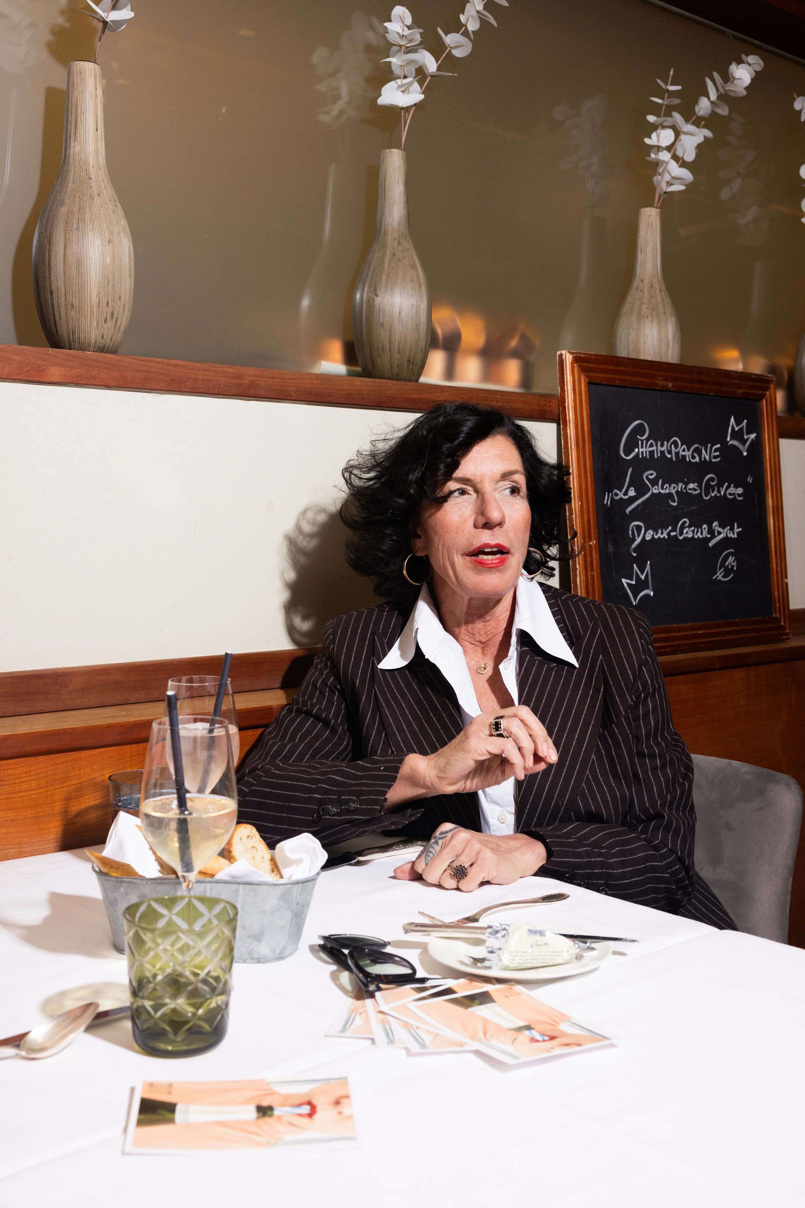 Porträt einer Frau im eleganten Anzug beim Mittagessen in einem Restaurant.