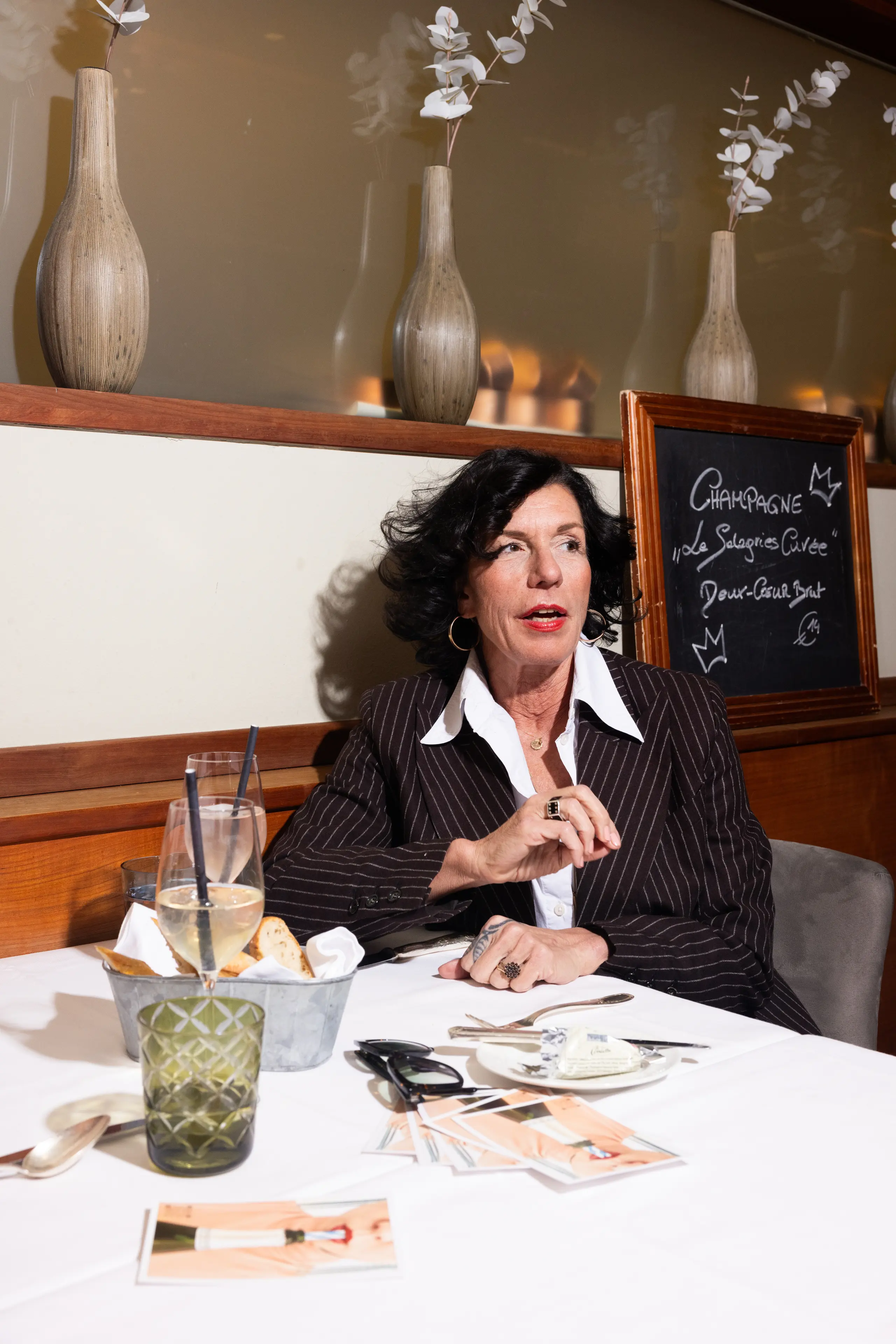 Porträt einer Frau im eleganten Anzug beim Mittagessen in einem Restaurant.