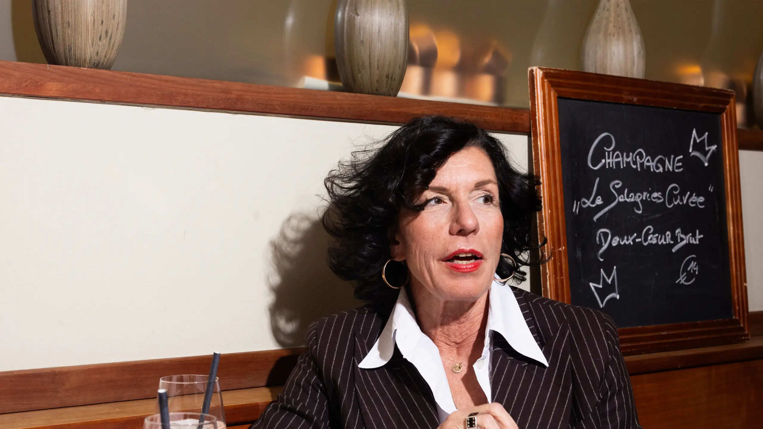 Porträt einer Frau im eleganten Anzug beim Mittagessen in einem Restaurant.