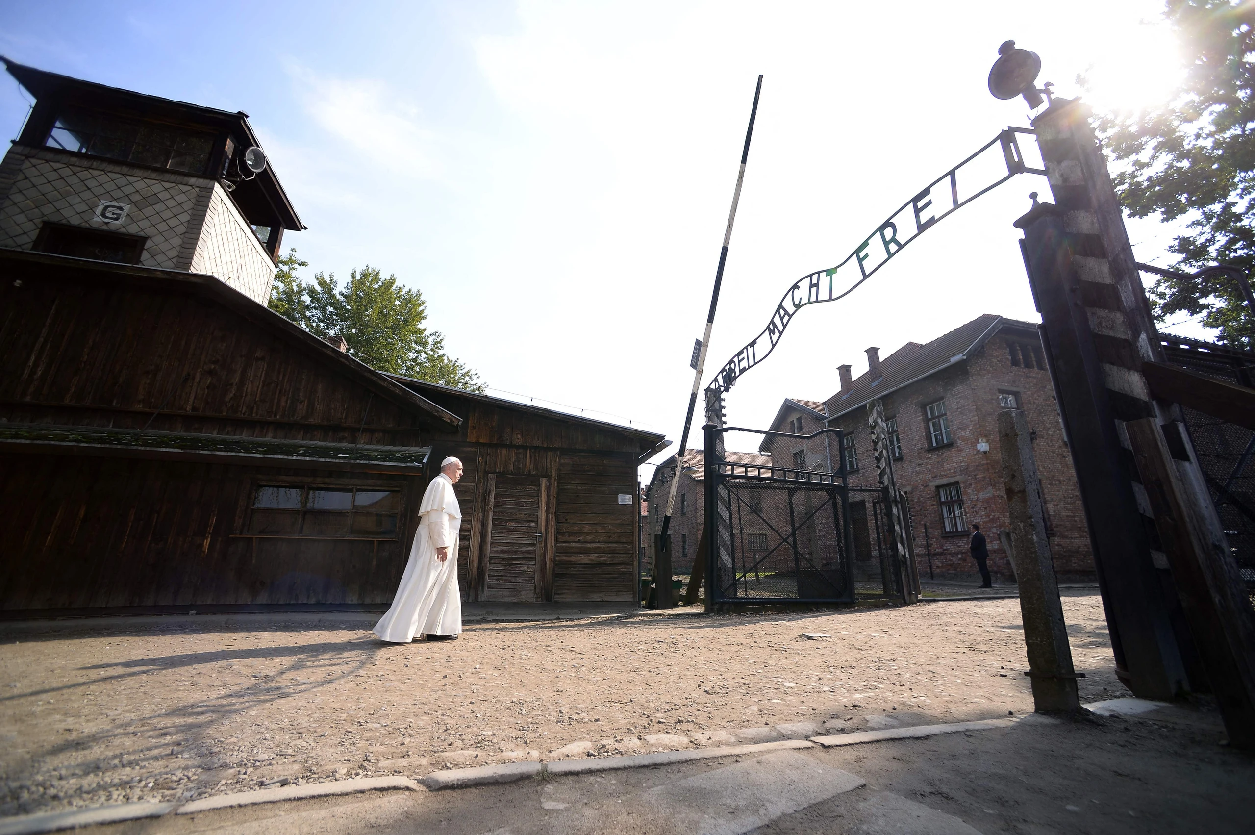 Papst Franziskus besucht am 29. Juli 2016 das ehemalige Konzentrationslager Auschwitz-Birkenau.  Er geht auf das Eingangstor mit der Aufschrift "Arbeit macht frei" zu.  Ein Foto von Filippo MONTEFORTE/AFP.