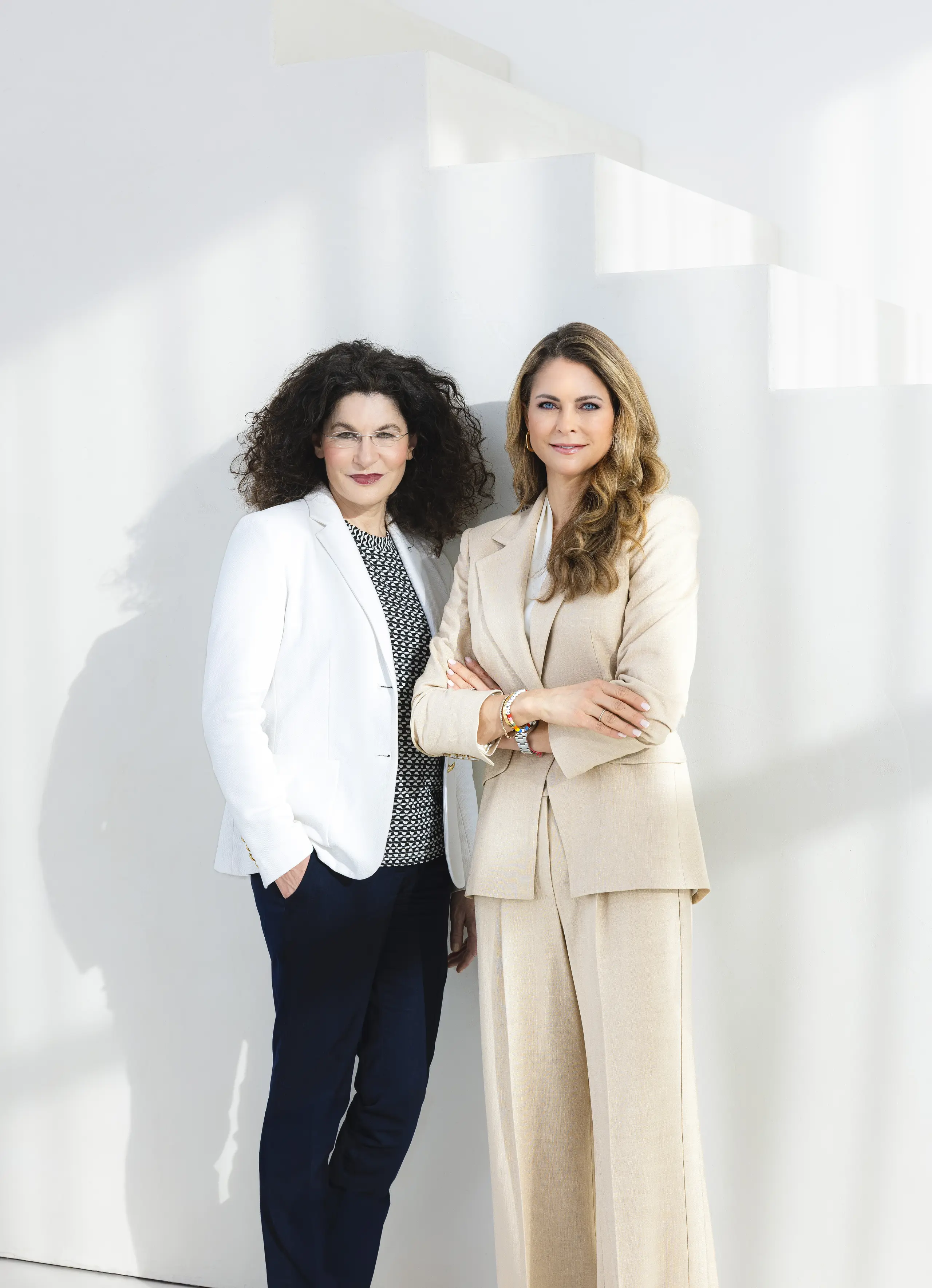Tina Müller (links) gemeinsam mit Prinzessin Madeleine (rechts) vor einer weißen Wand
