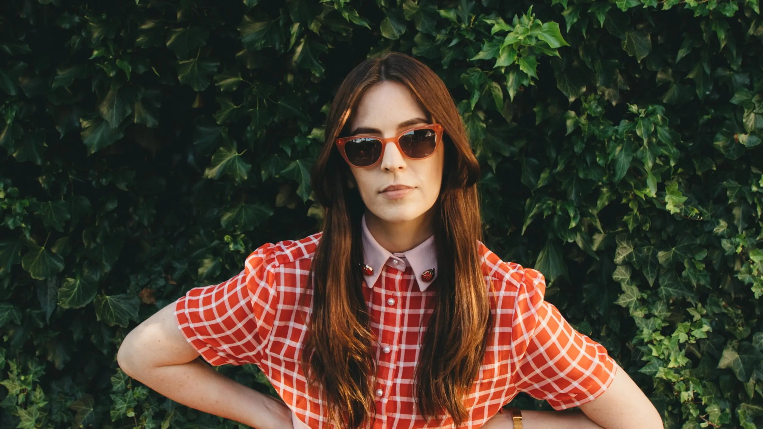 Gemma Styles vor einer hohen Hecke