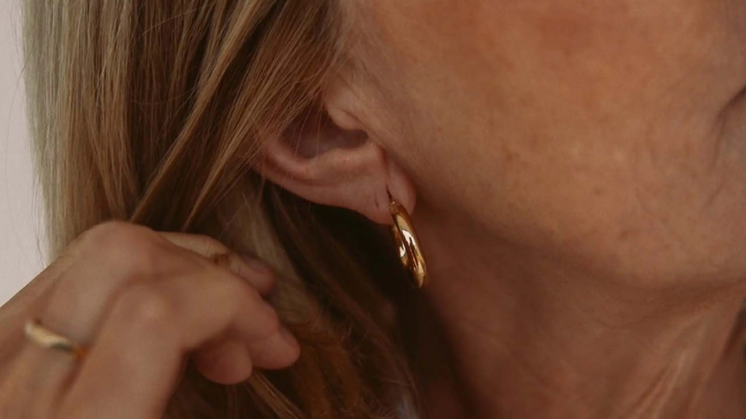 Ältere Dame mit goldenem Ohrring und Ring