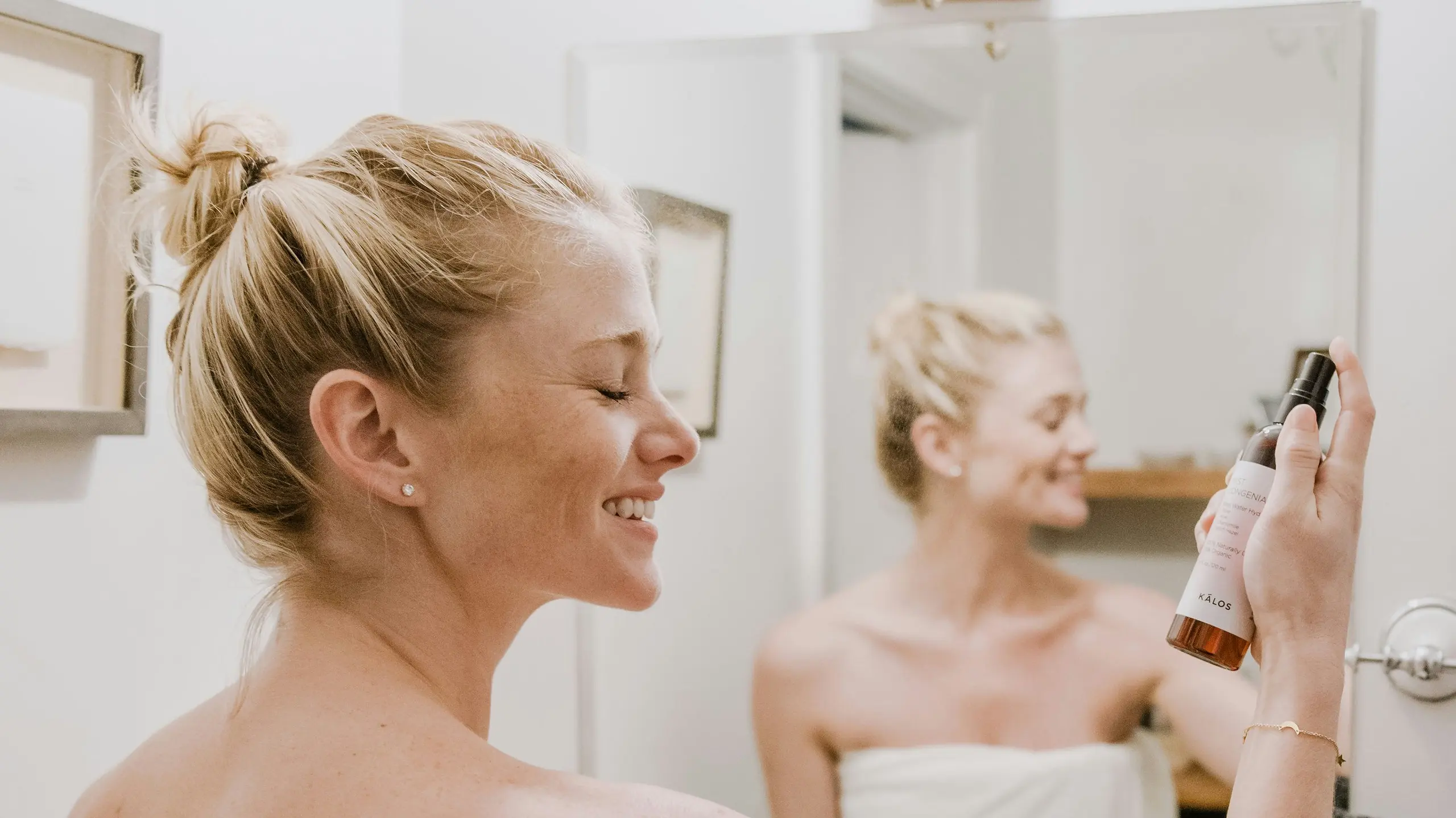 Eine Frau steht im Badezimmer und nutzt Hautpflege