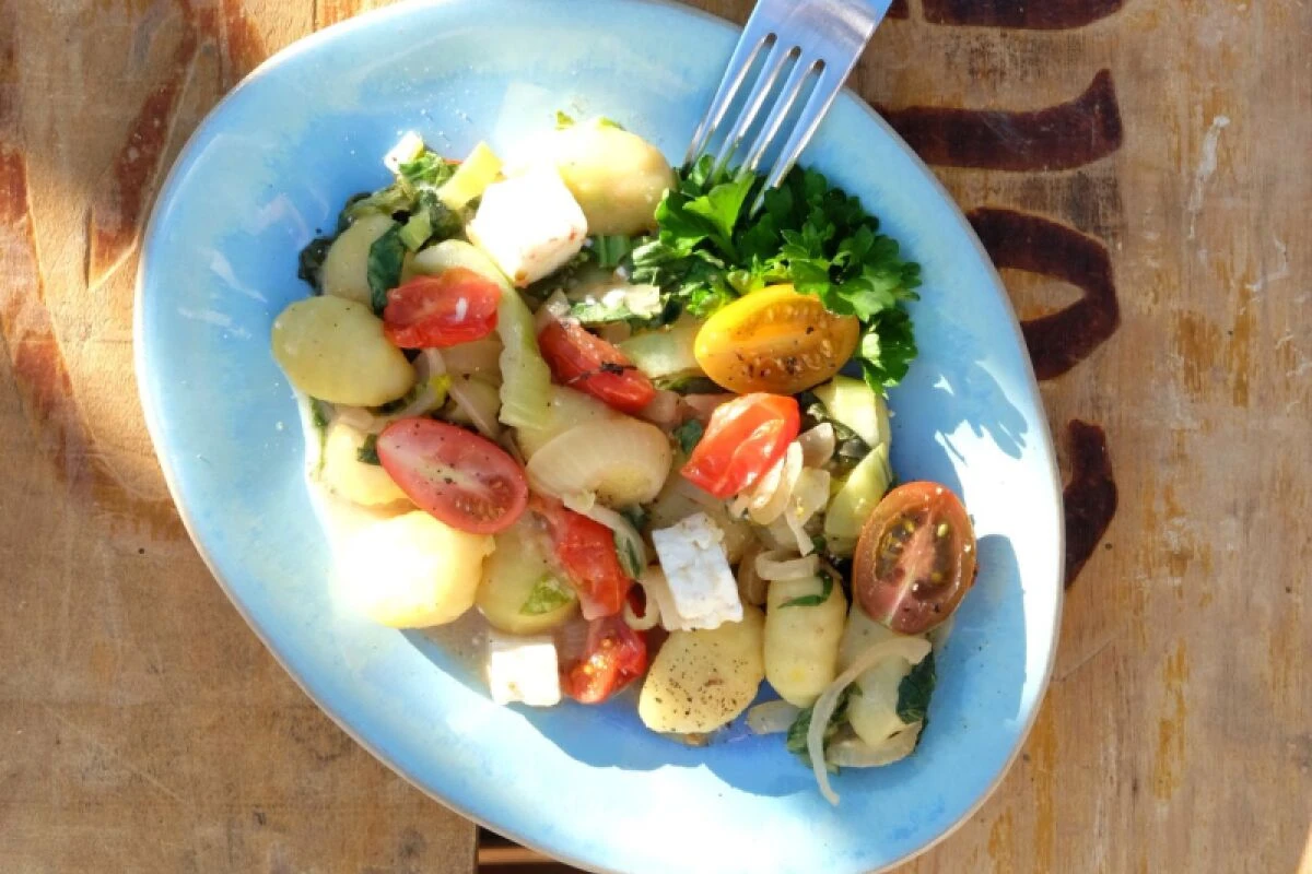 Gnocchi werden mit Pak Choi, Cocktailtomaten und Kokosmilch zubereitet