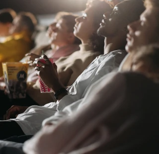 ©  Kinobesucher genießen einen Film im Kino. Entspannte Zuschauer in Reihen sitzen und schauen sich einen Film an.