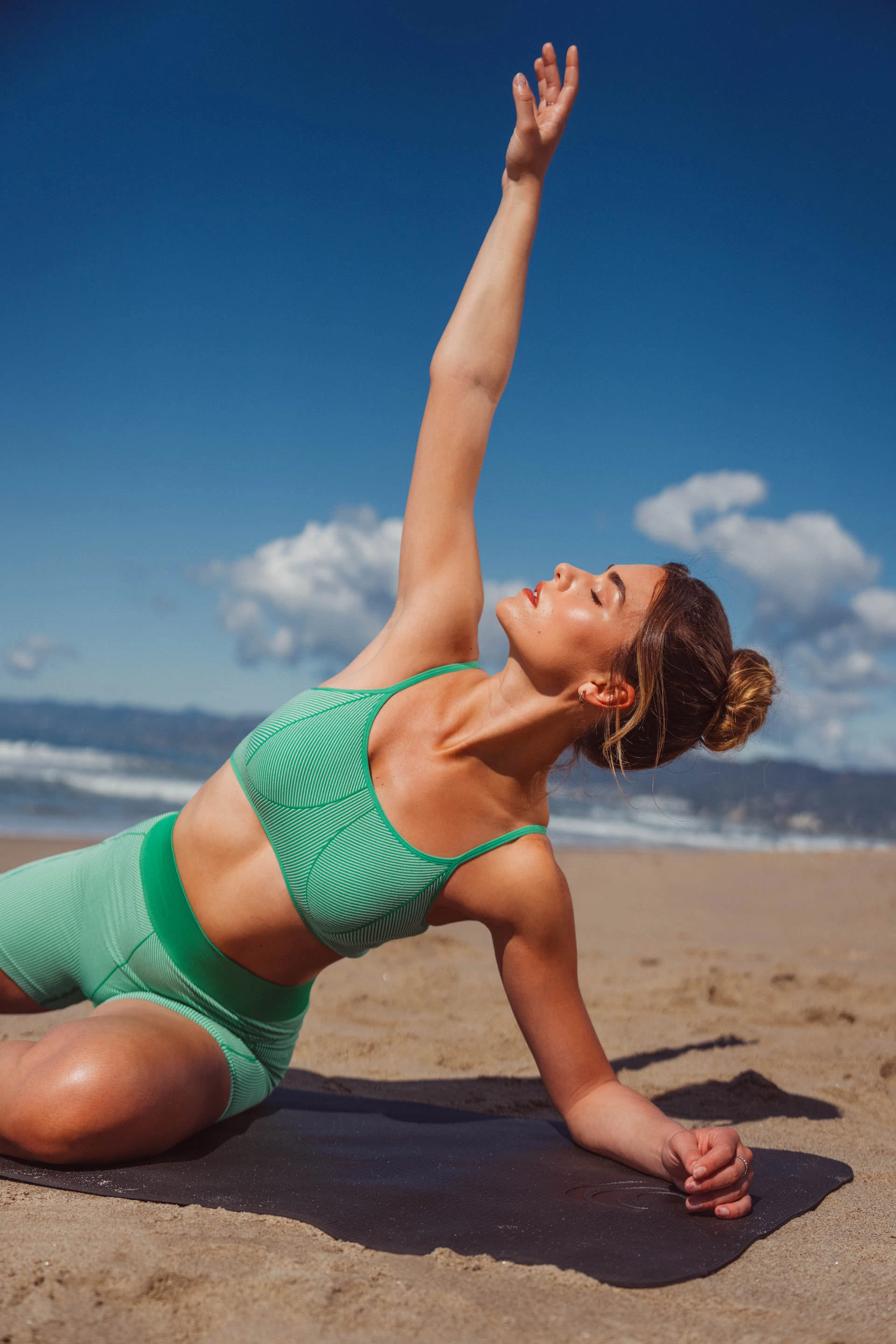 Eine Frau macht Yoga am Strand
