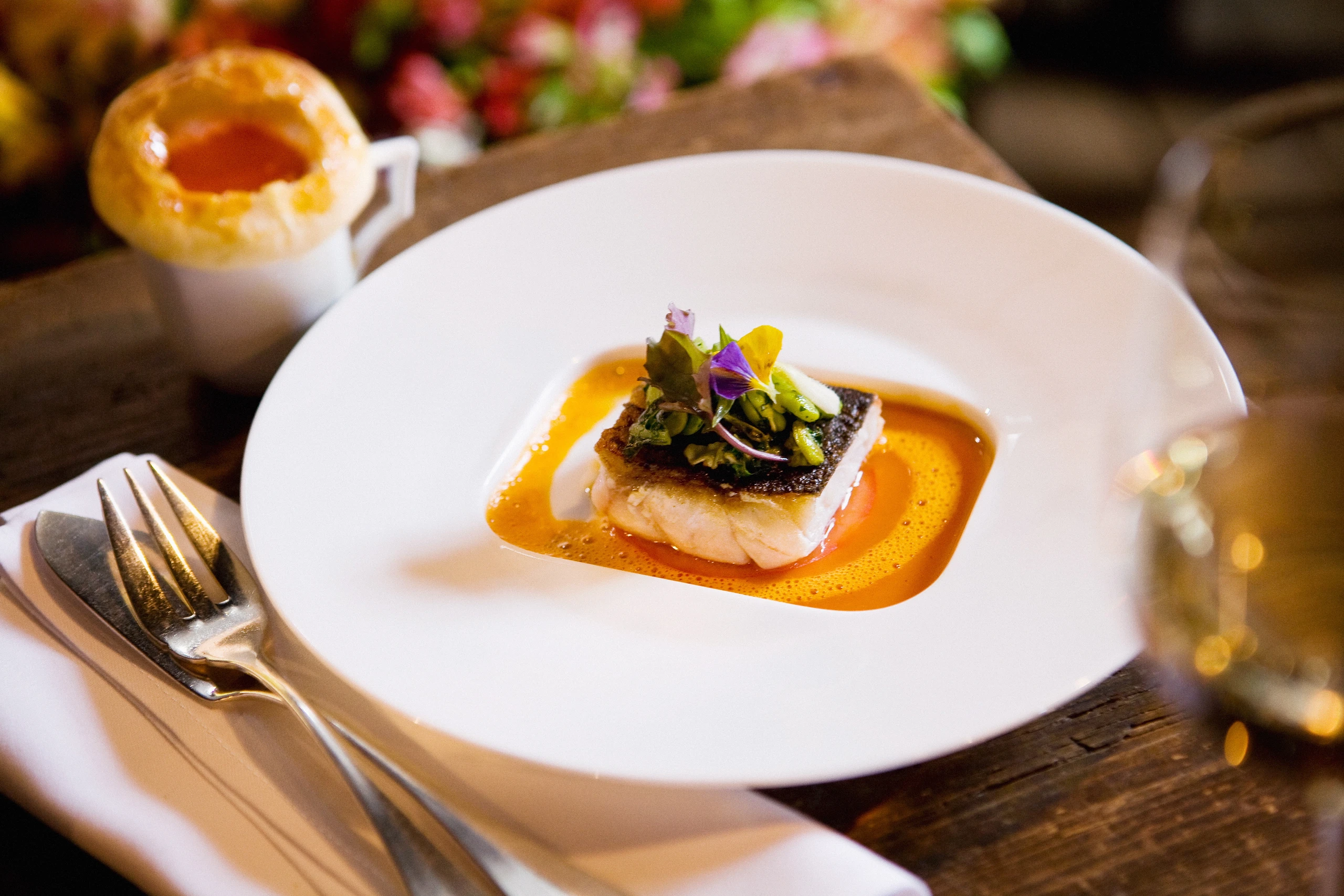 Wolfsbarsch mit Paradeisern, Saubohnen und Paradeissuppe