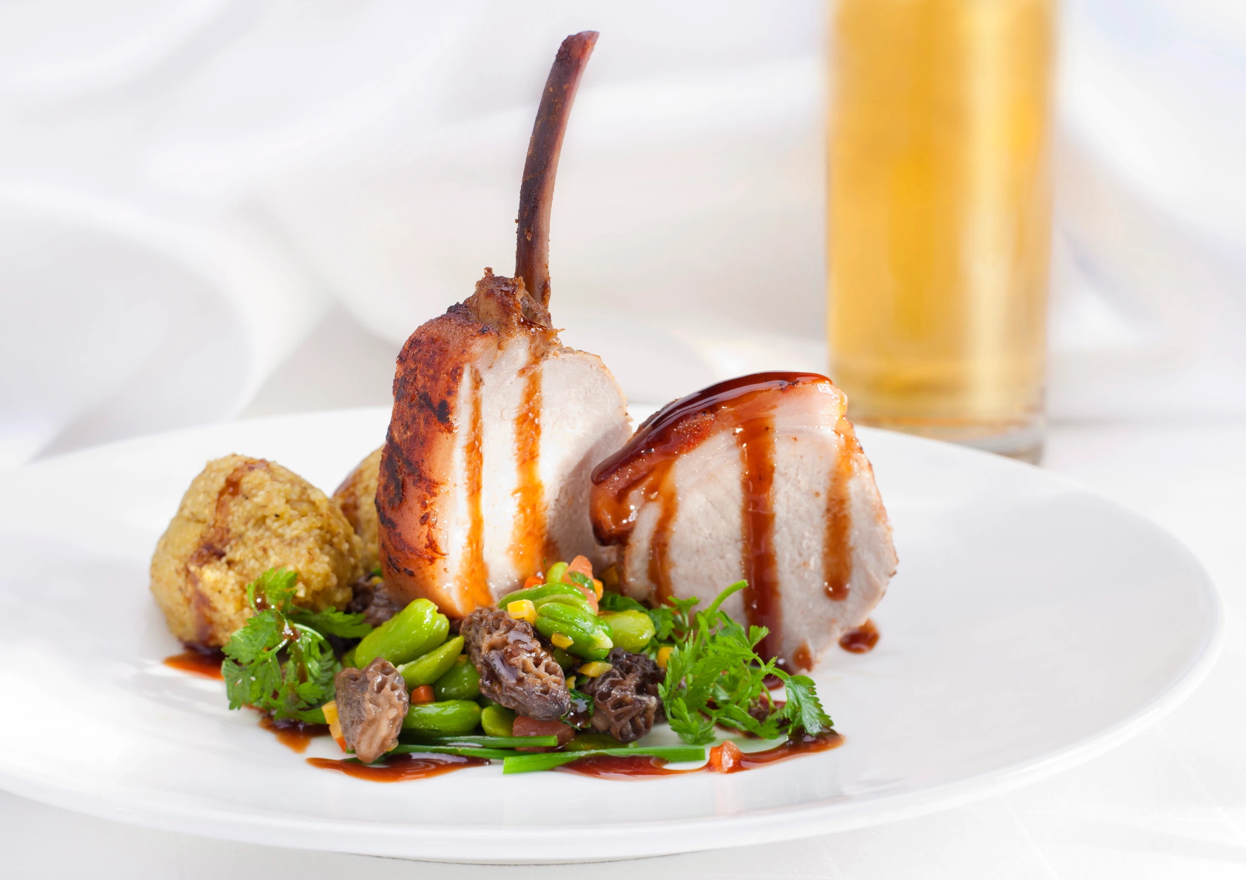 Milchferkelkrone auf Bohnen-Morchelragout und Riebel