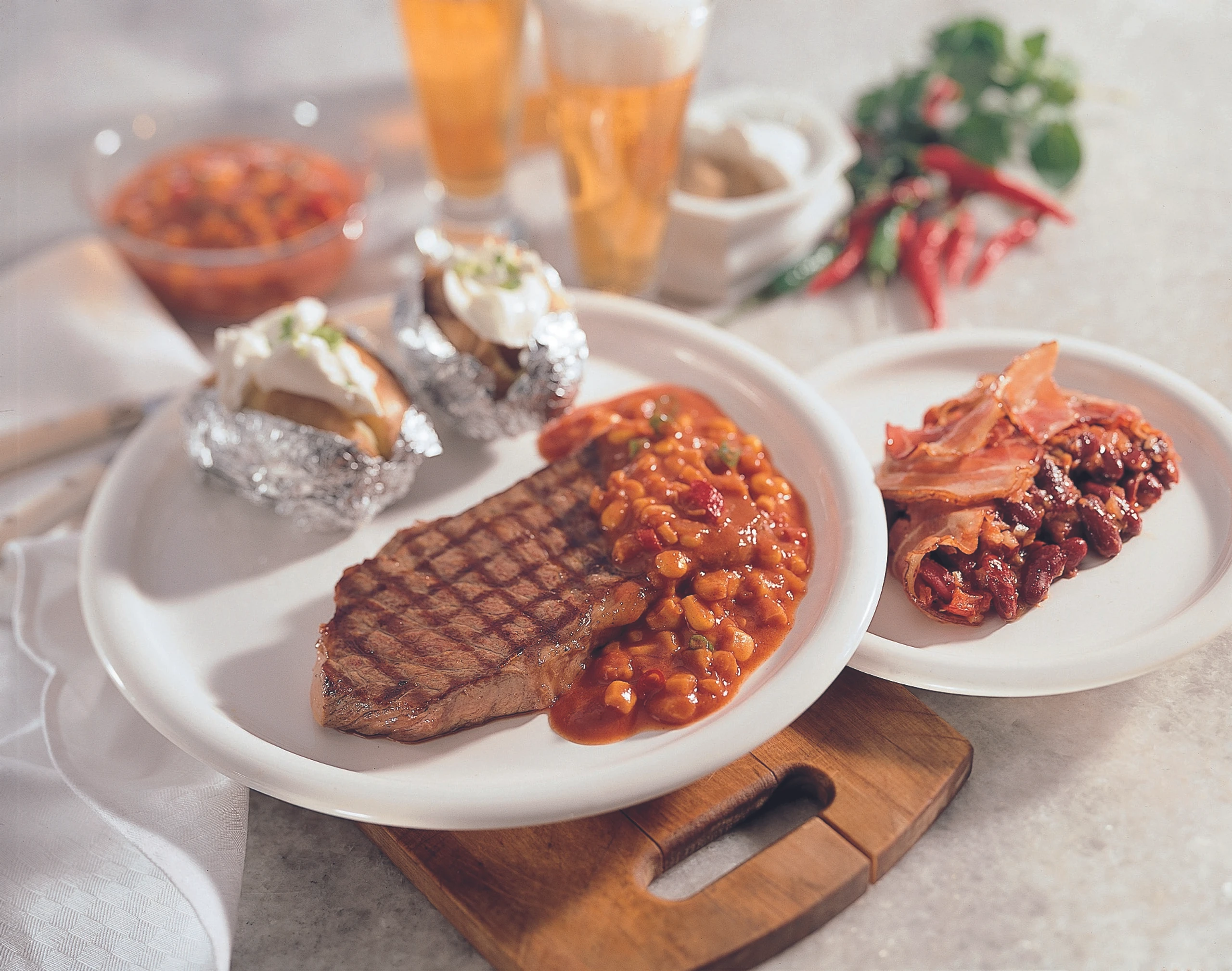 Gegrilltes Entrecôte mit Barbecue-Sauce, Baked Beans, Folienerdäpfeln