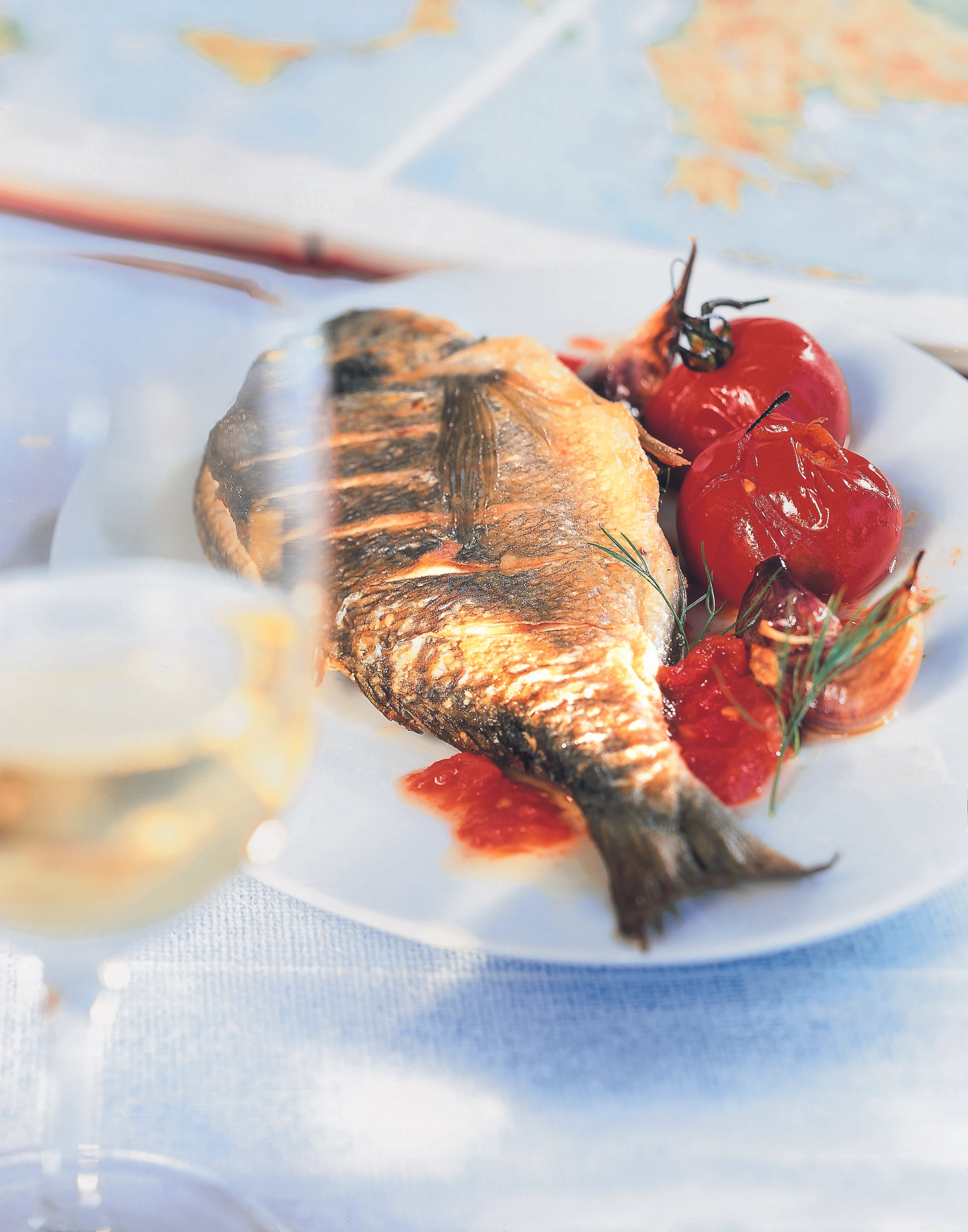 Gegrillte Goldbrasse mit Knoblauch und Paradeisern