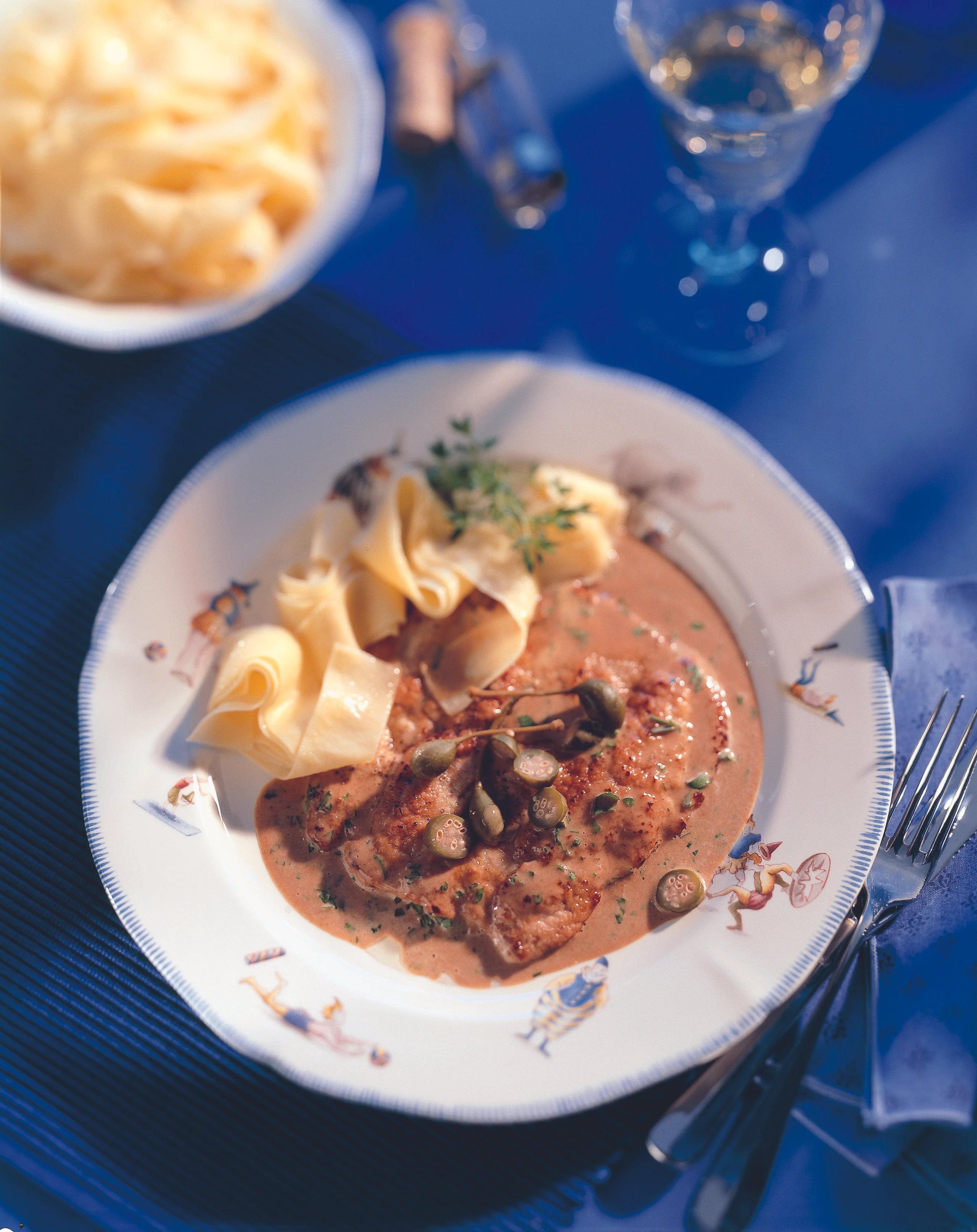 Gebratene Kalbsschnitzel mit Kapern-Rahmsauce und Bandnudeln