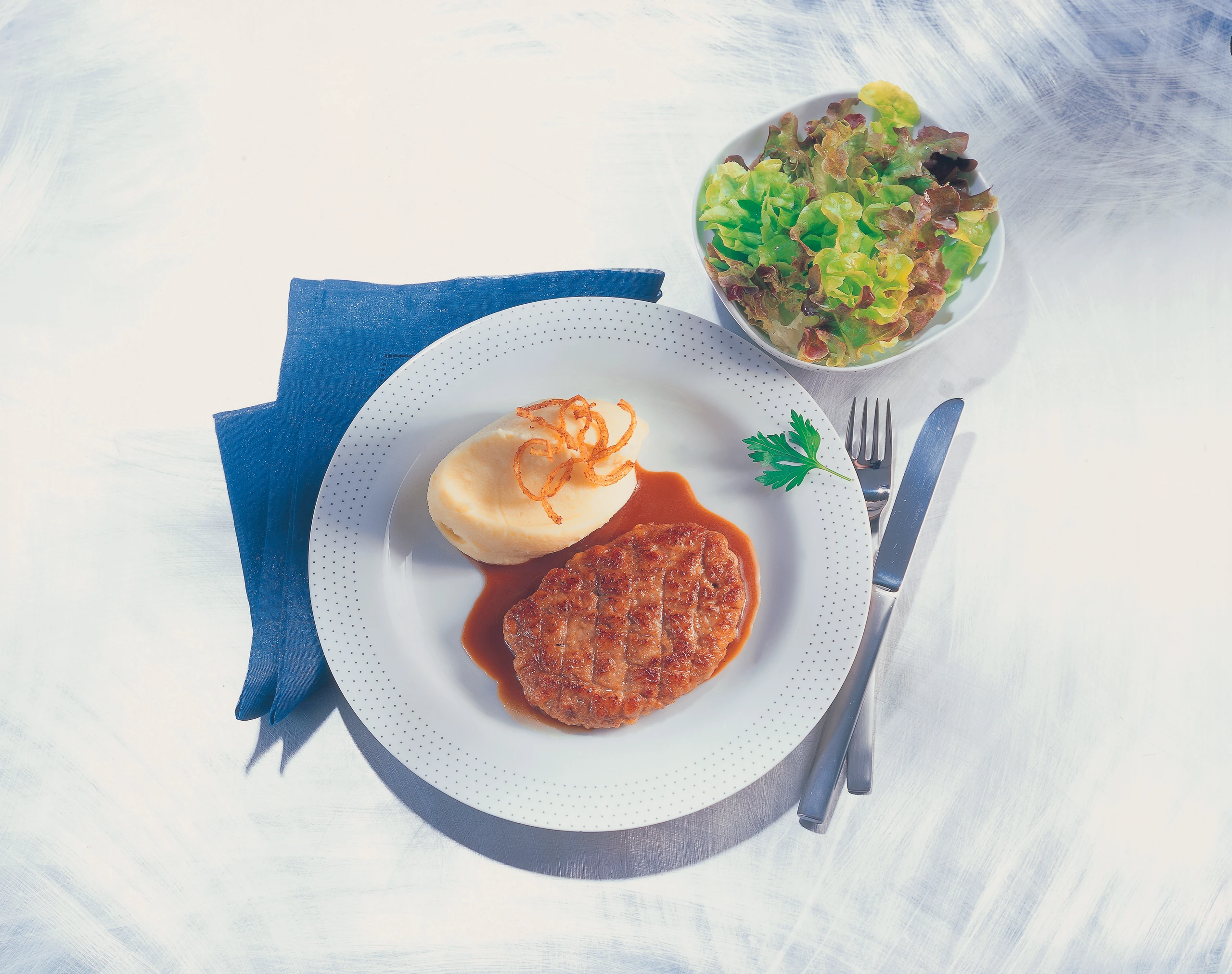 Faschiertes Butterschnitzel mit Erdäpfelpüree und Eichblattsalat