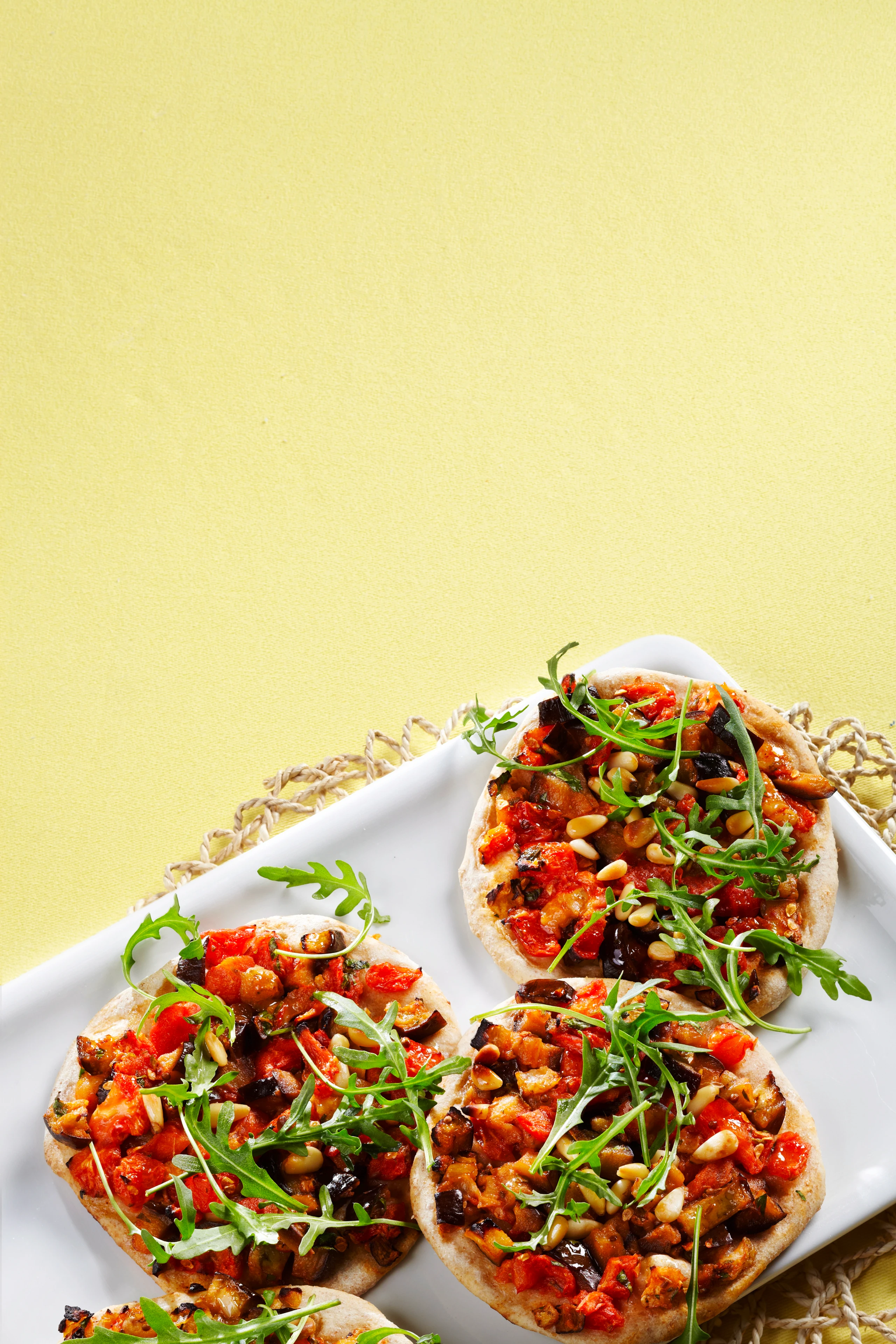 Mini-Pizzen mit Melanzani, Pignoli und Rucola