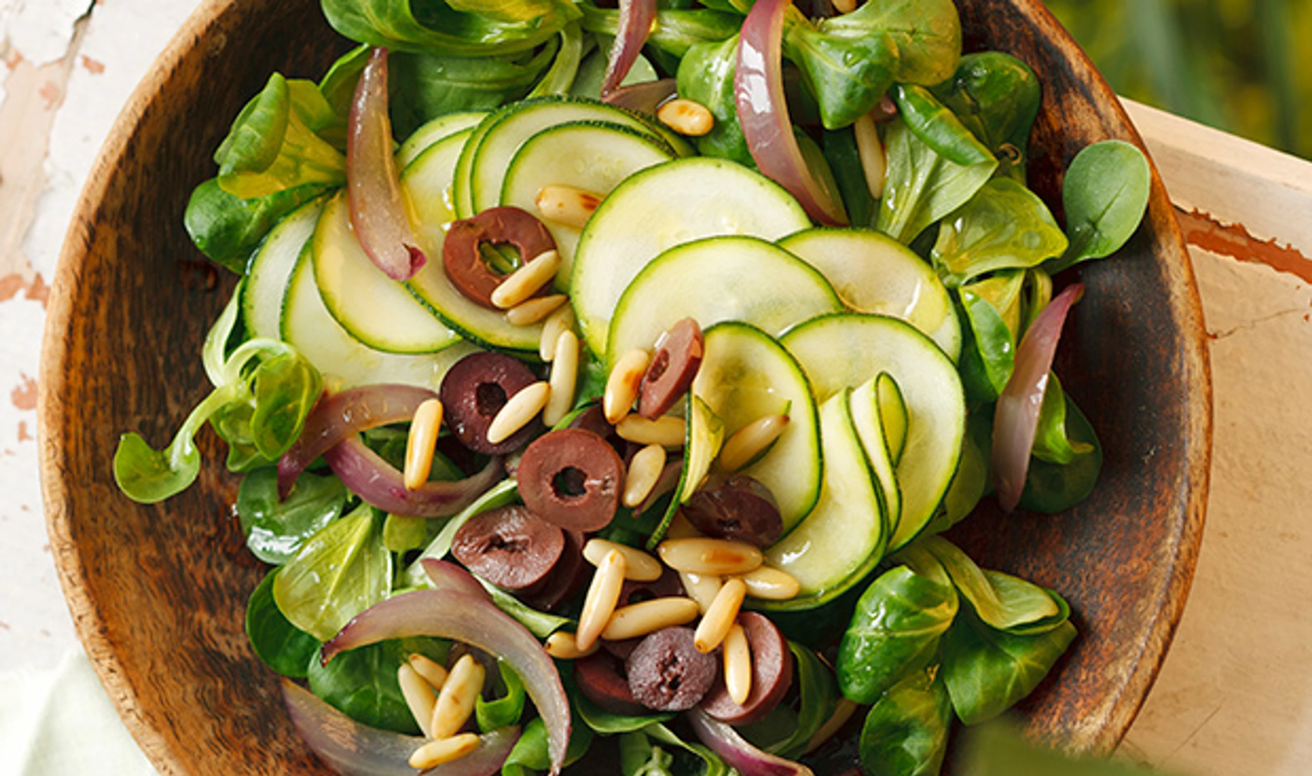 Vogerlsalat mit Zucchini, Oliven und Pignoli