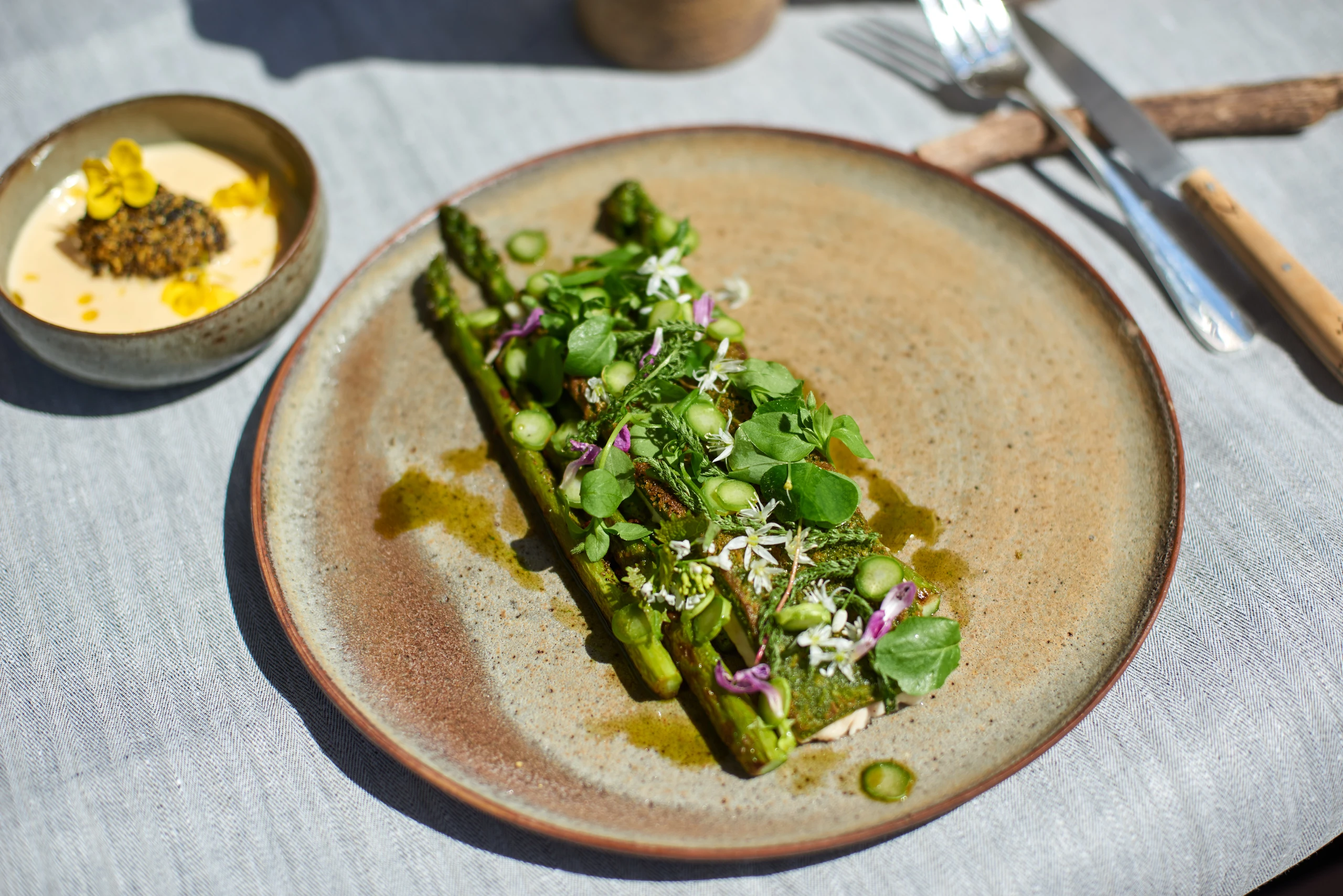 Überbackener Saibling mit Spargel, Wildkräutern und Rapserdäpfeln