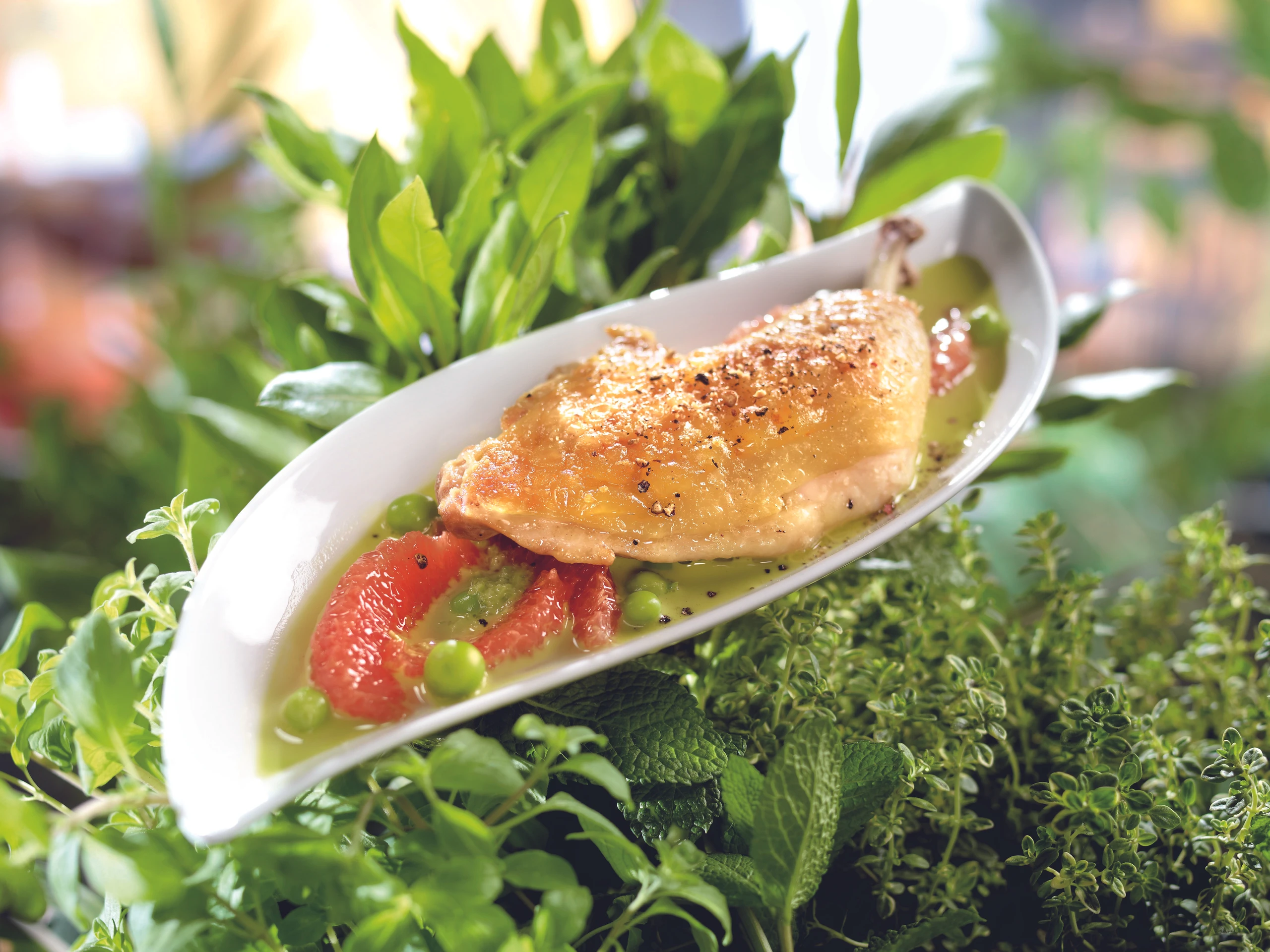 Knusprige Hühnerkeule mit Grapefruits und Erbsen