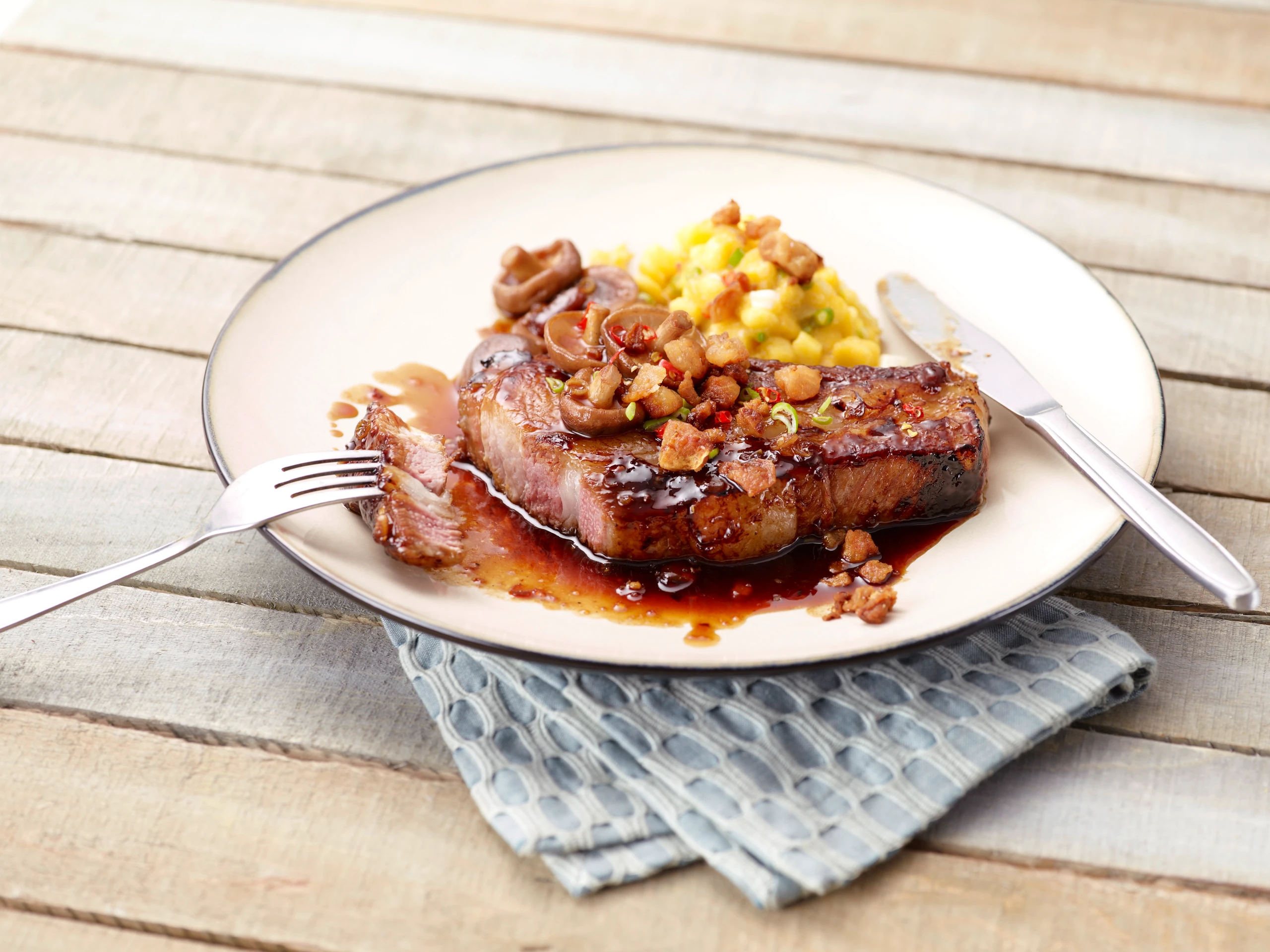 Asiatisch mariniertes Kotelett mit Shiitake, Mangosalat und Grammeln