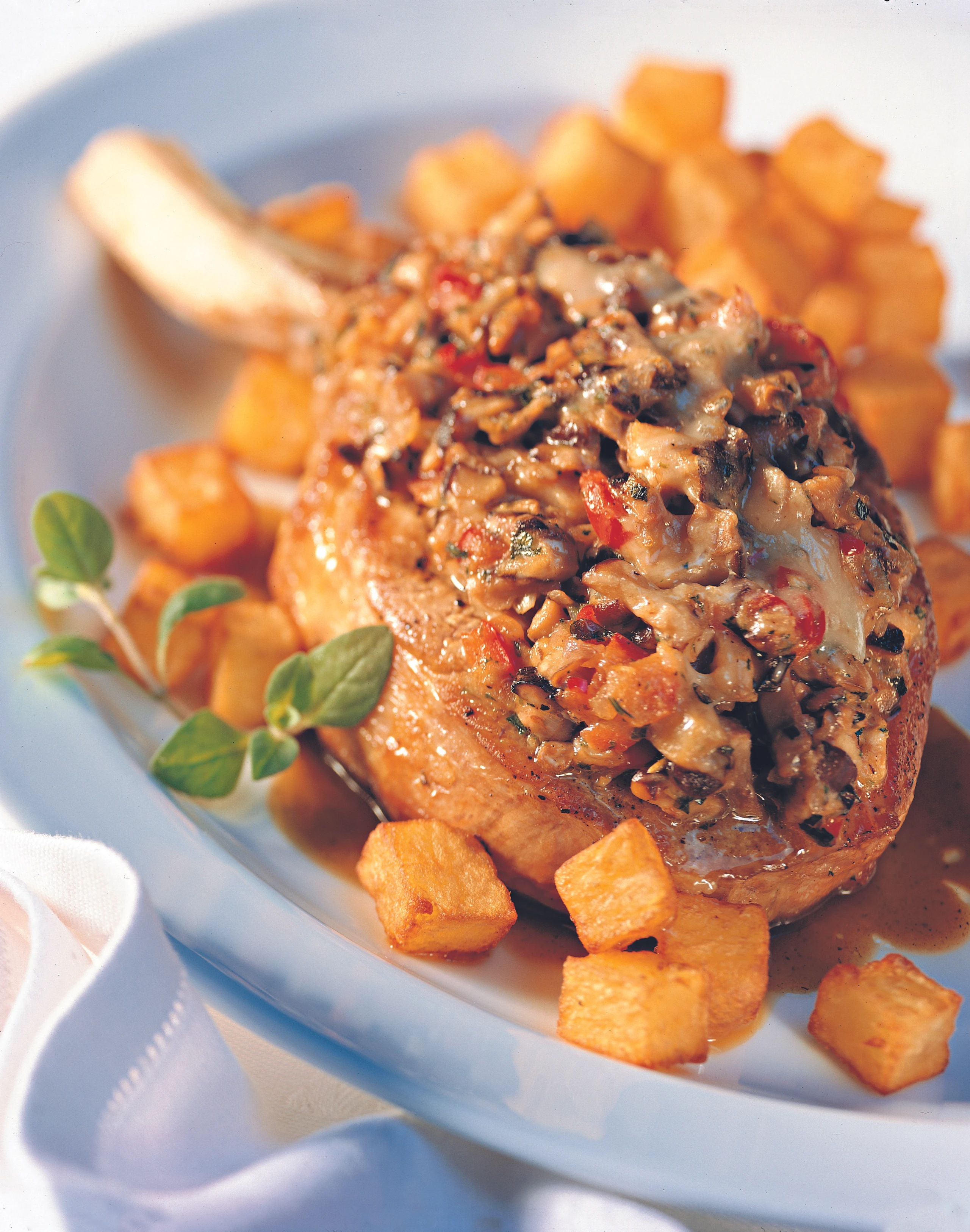 Überbackene Schweinskoteletts mit knusprigen Erdäpfelwürfeln