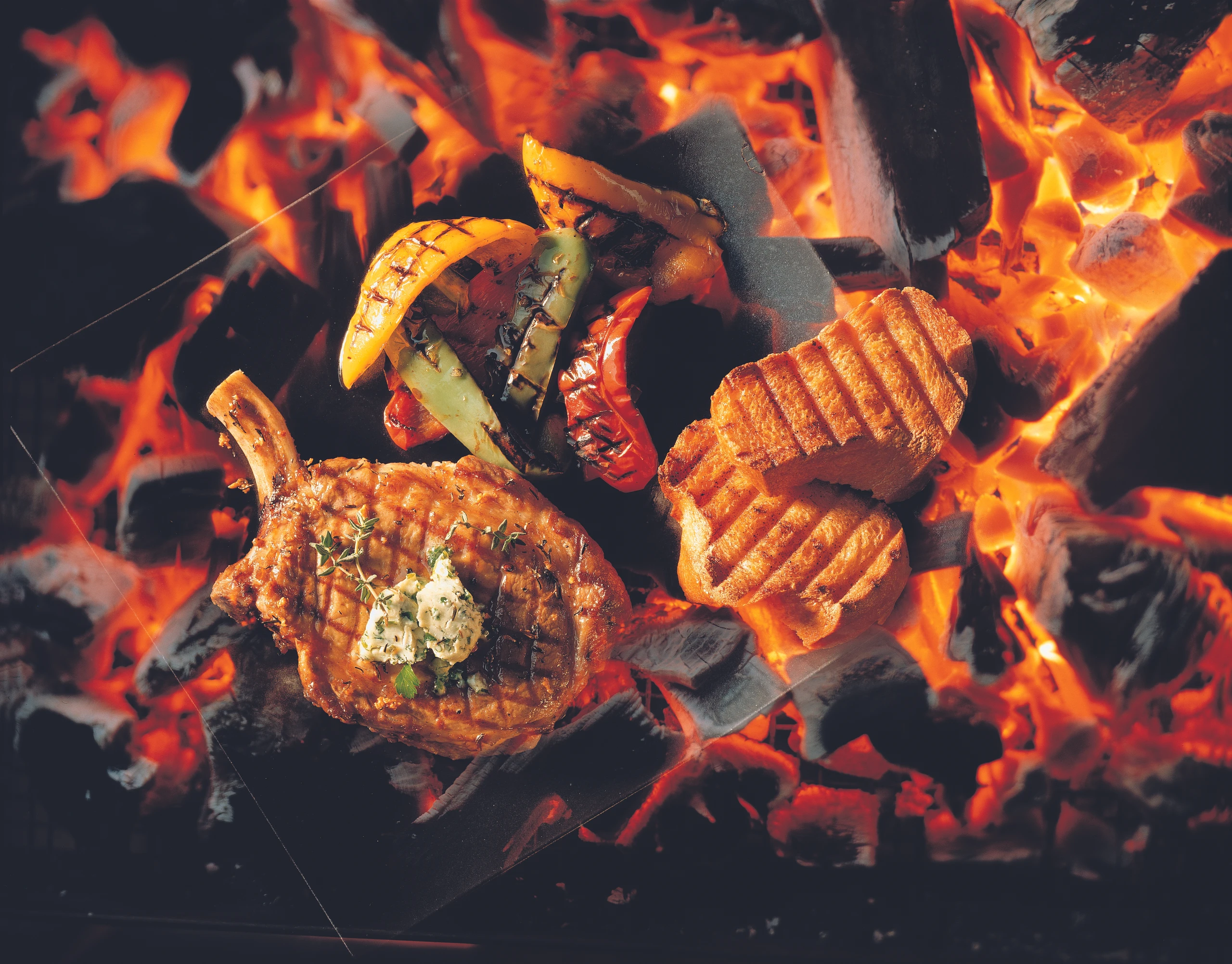 Gegrillte Schweinskoteletts mit Knoblauch-Thymian-Marinade und Kräuterbutter