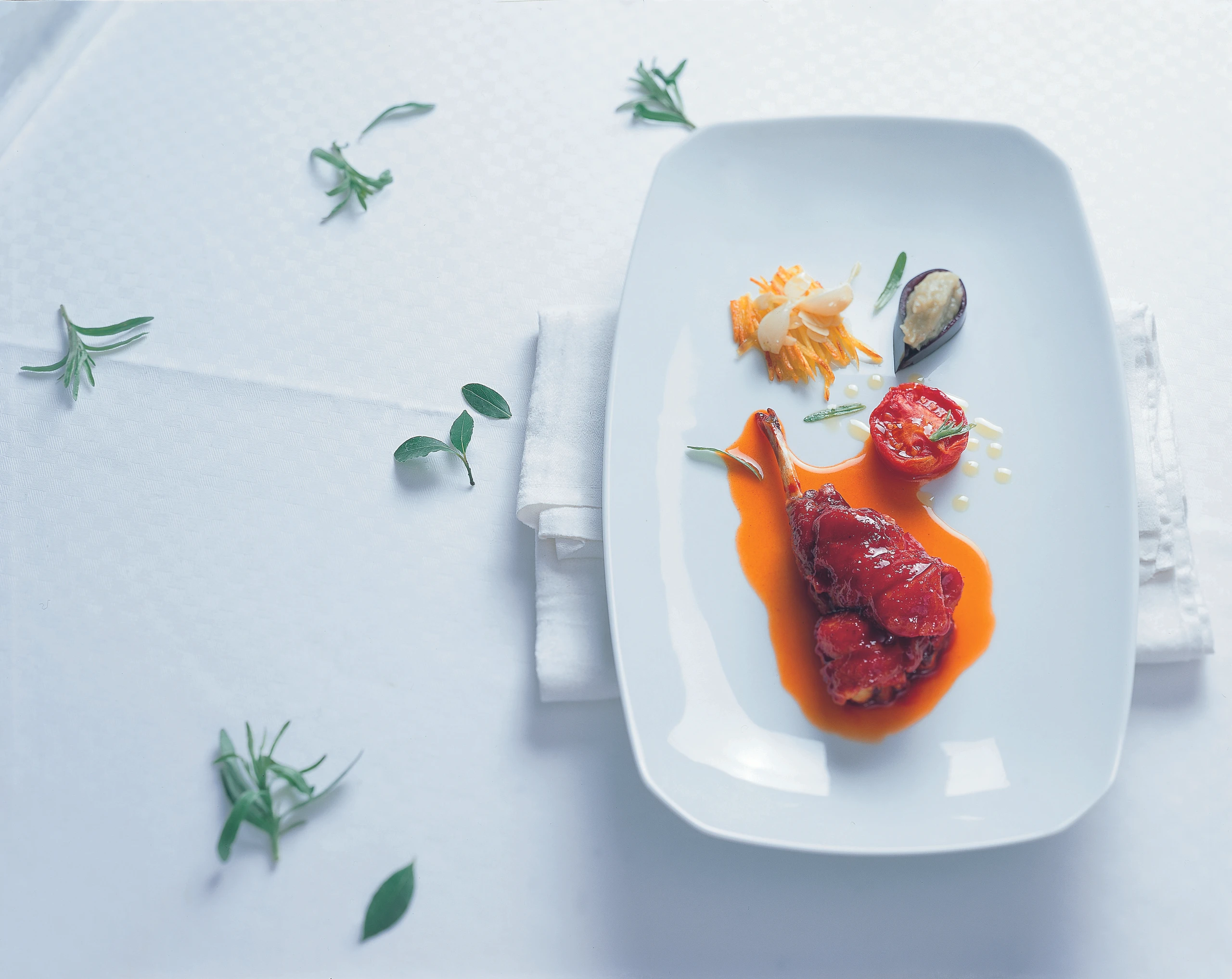 Kaninchenkeule im Tomaten-Paprikasaft mit Mandelrösti