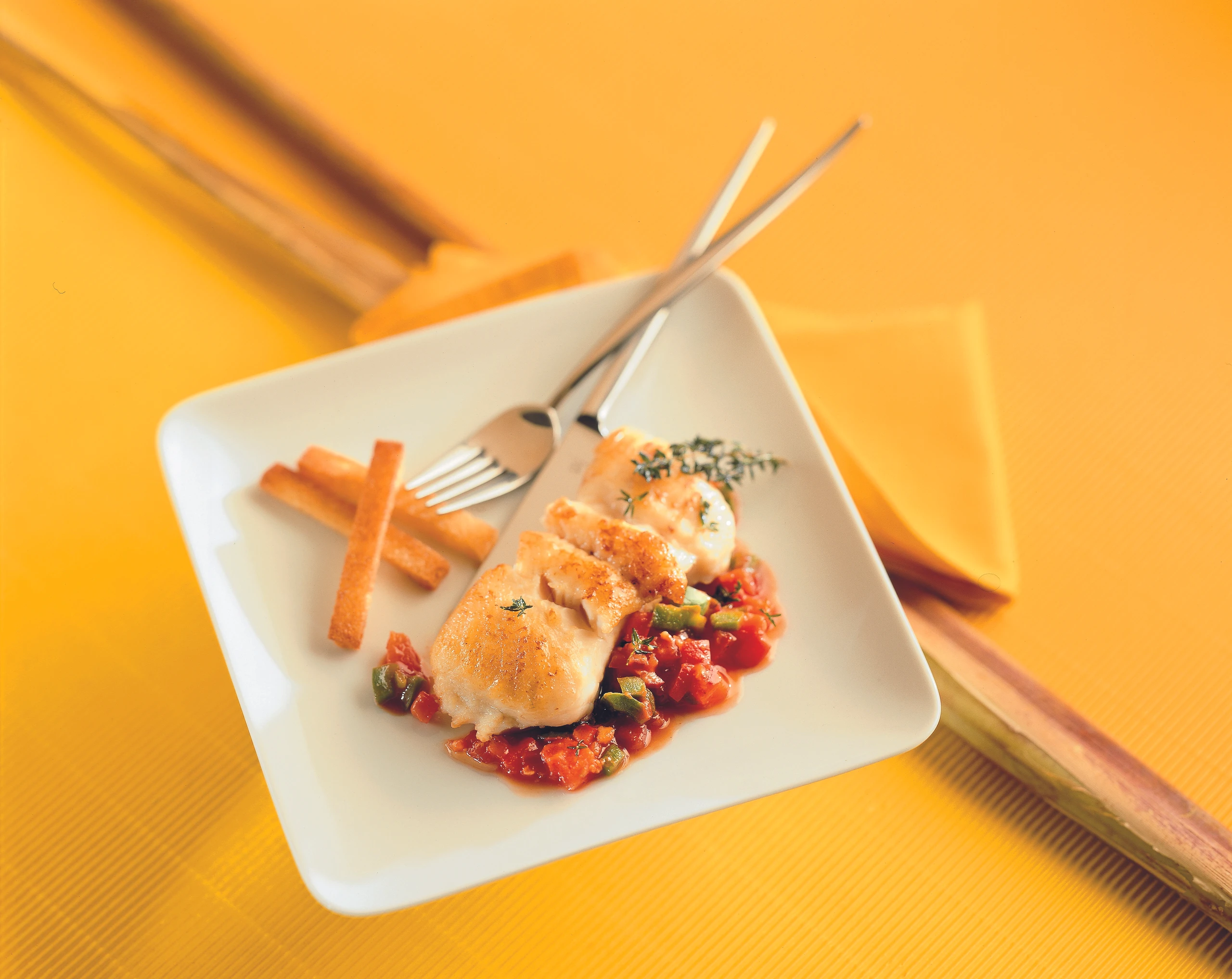 Welsfilet mit Paradeis-Paprikasauce und knusprigen Brotstreifen