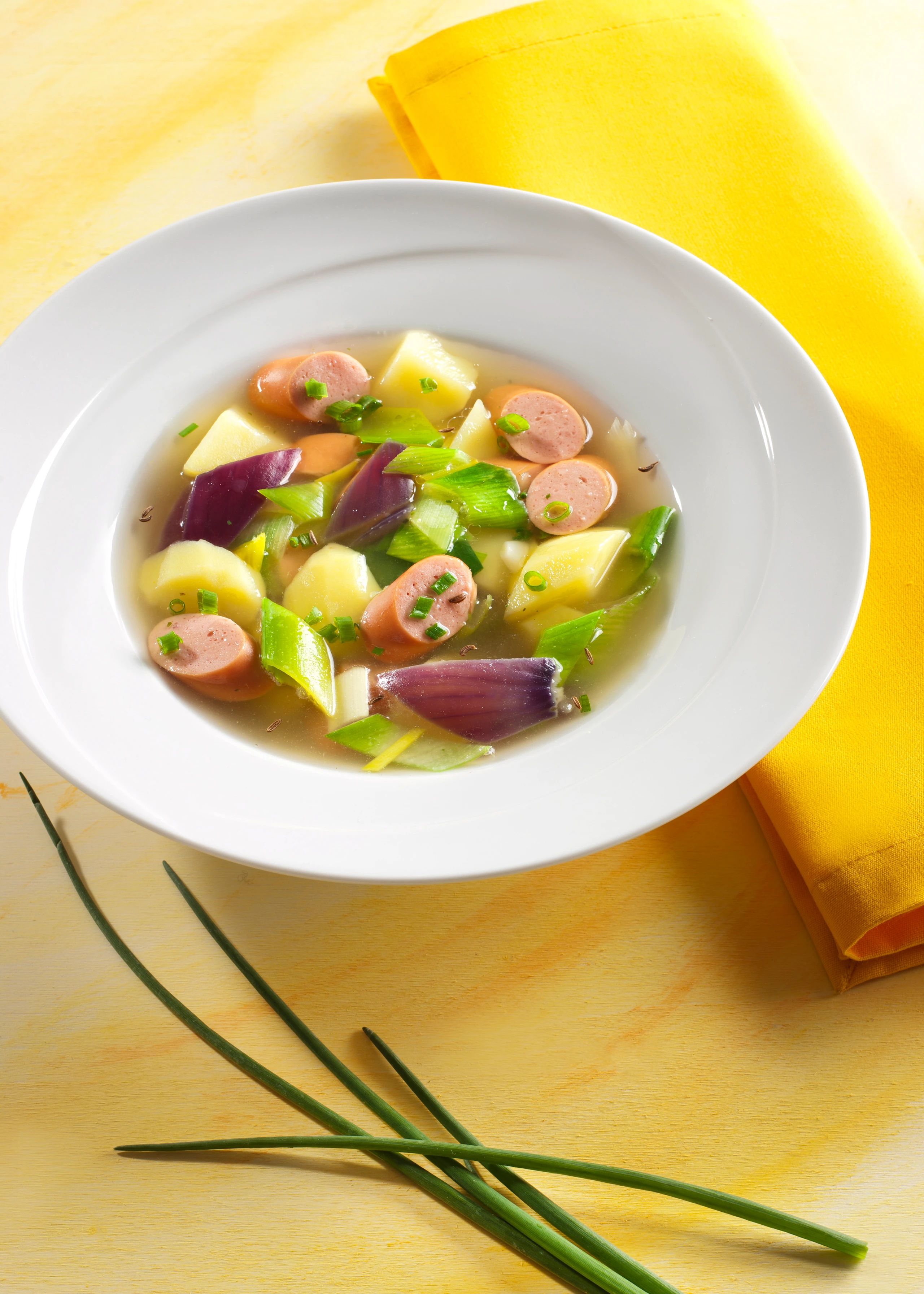 Klare Erdäpfel-Lauchsuppe mit Würsteln