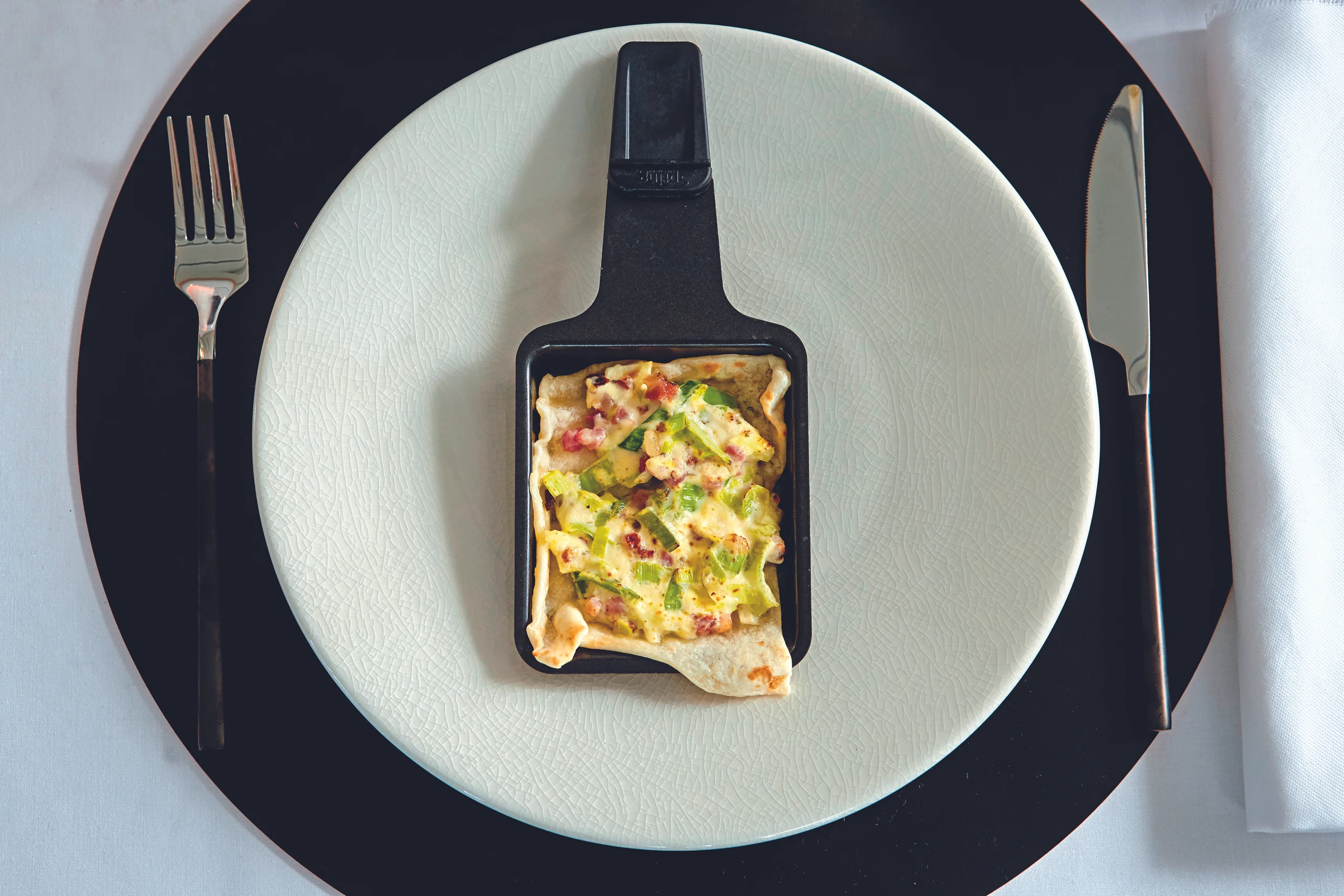 Raclette: Flammkuchen-Pfännchen mit Lauch und Speck