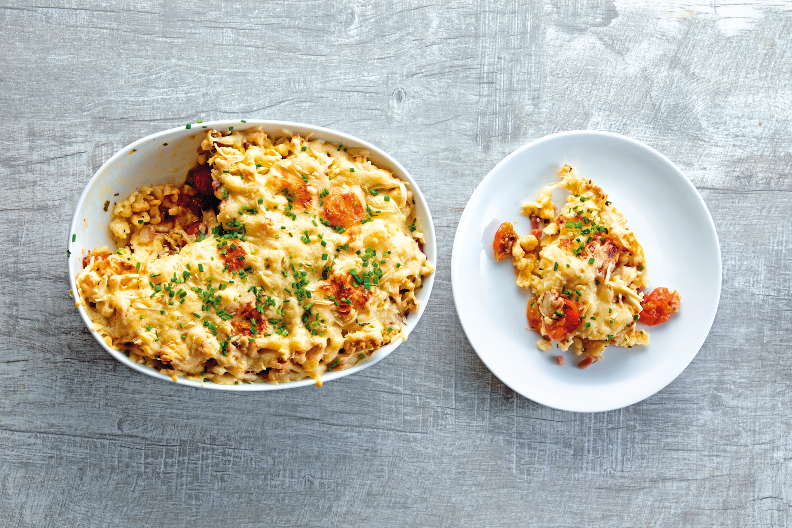 Überbackene Nockerl mit Speck und Paradeisern