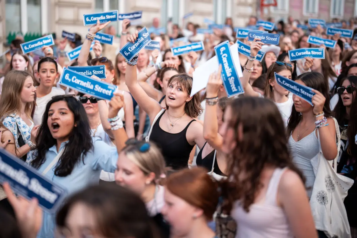 Swifties mit "Cornelia Street"-Schildern in der Wiener Corneliusgasse