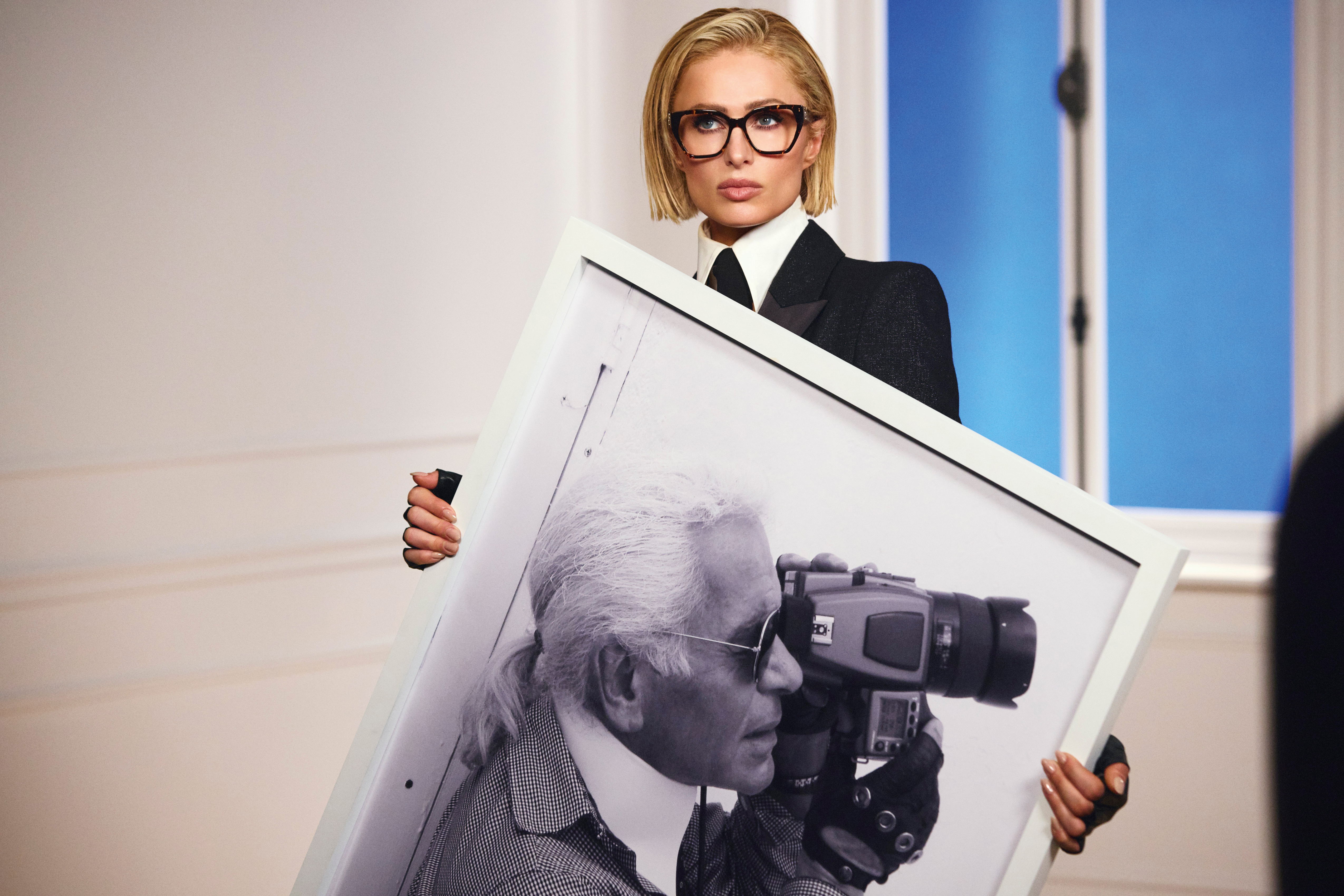 Paris Hilton hält ein großes Schwarz-Weiß.Bild von Karl Lagerfeld wie er gerade fotografiert
