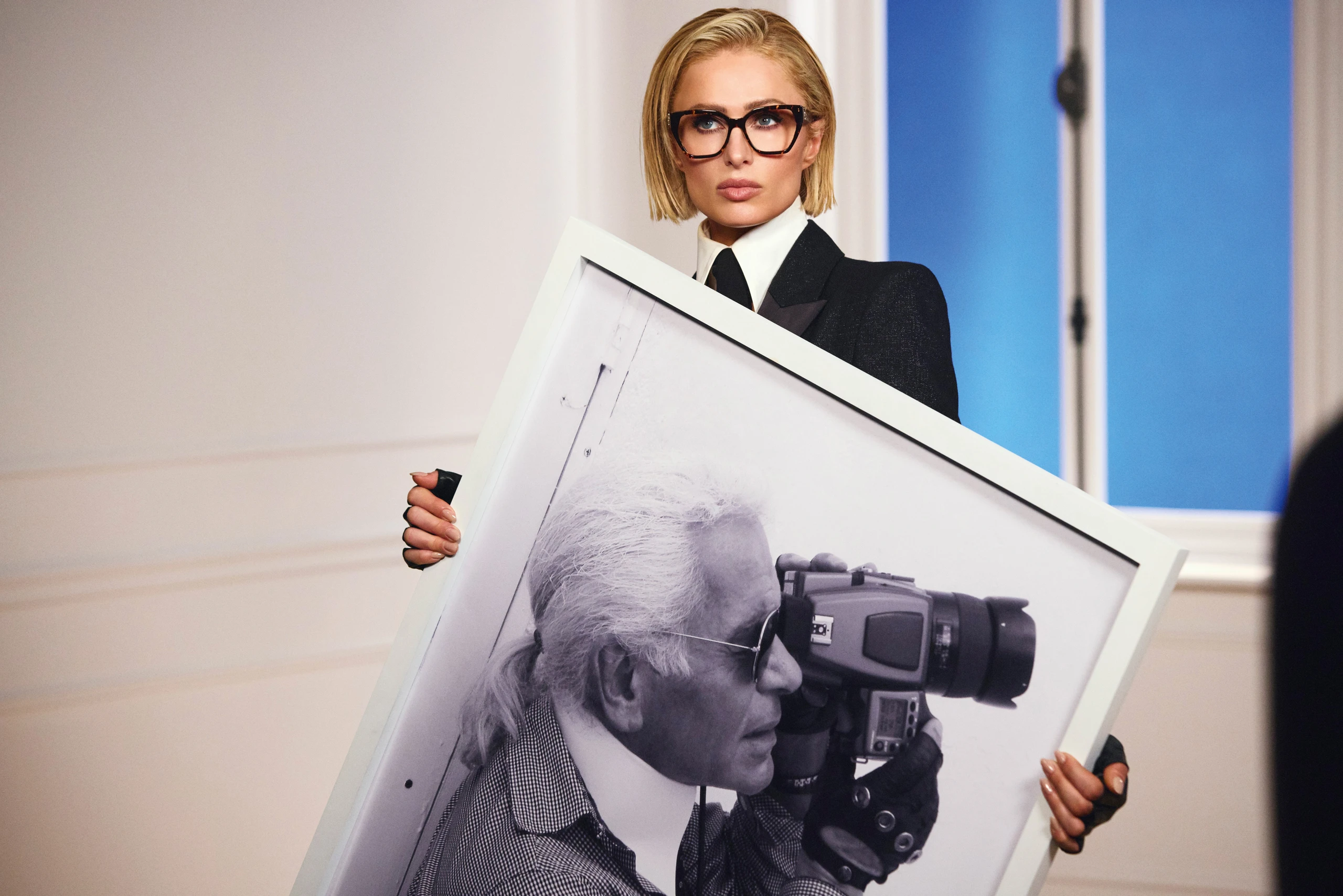 Paris Hilton hält ein großes Schwarz-Weiß.Bild von Karl Lagerfeld wie er gerade fotografiert