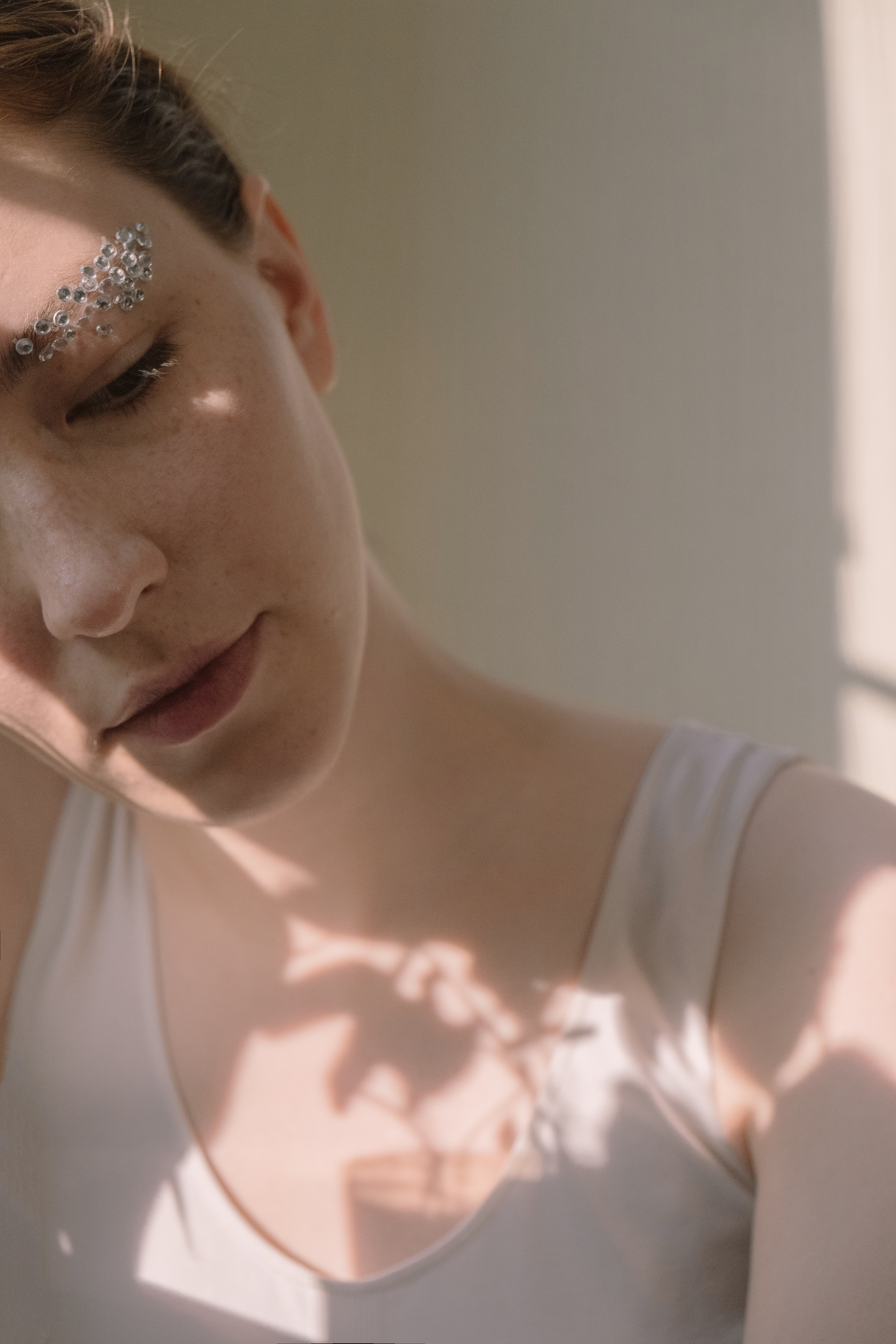 Frau mit Glitzersteinen auf Augenbrauen