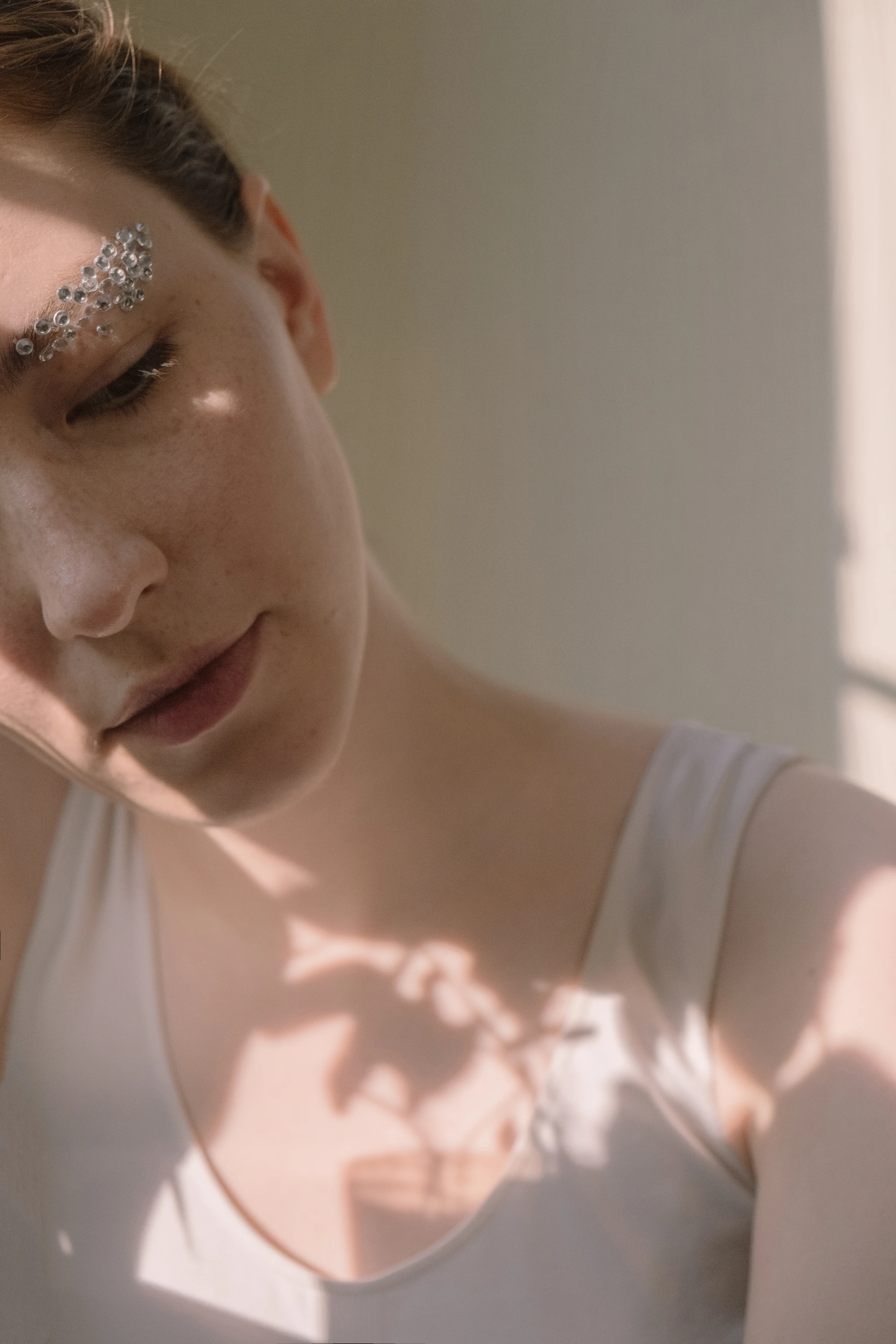 Frau mit Glitzersteinen auf Augenbrauen