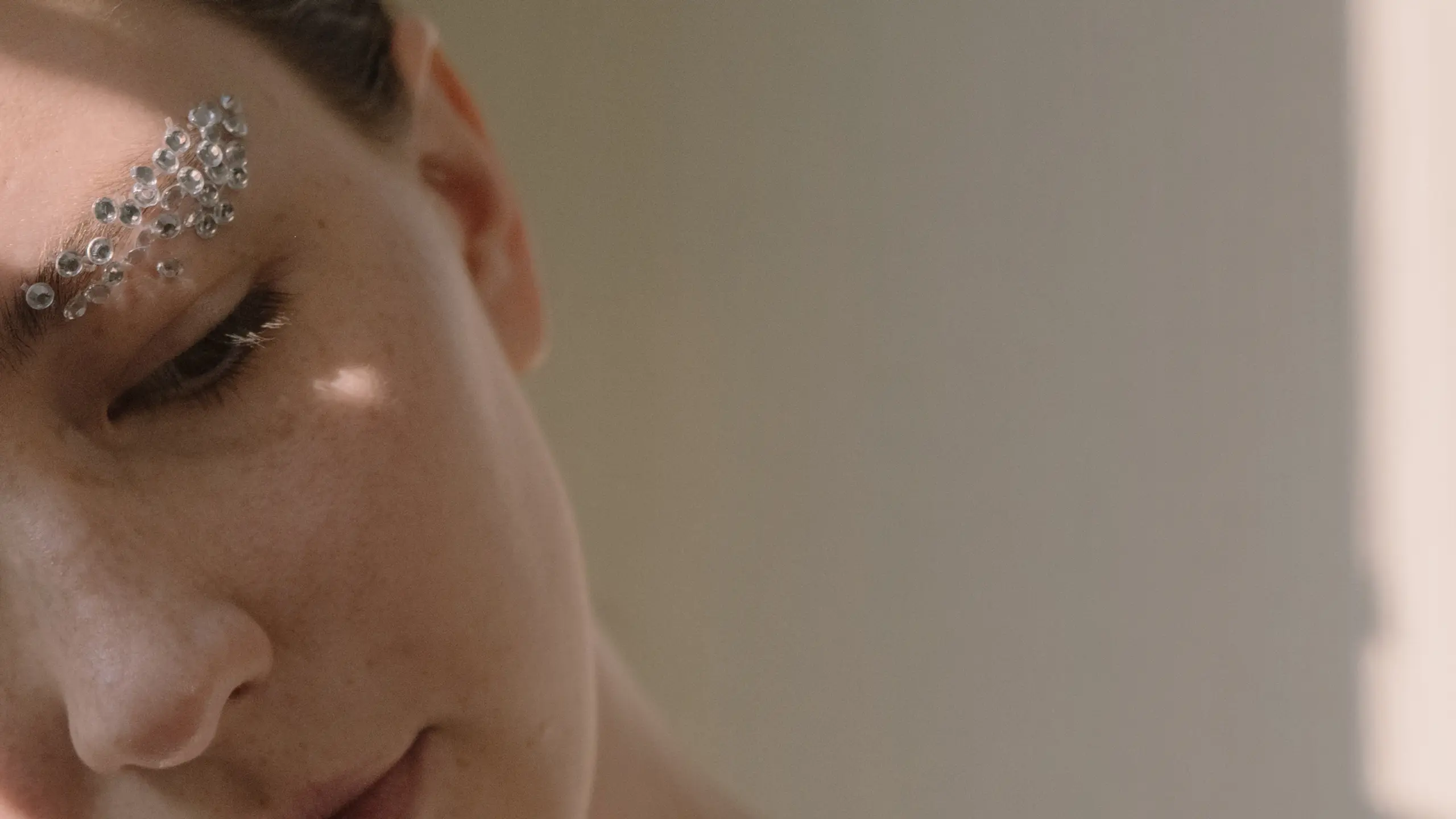 Frau mit Glitzersteinen auf Augenbrauen