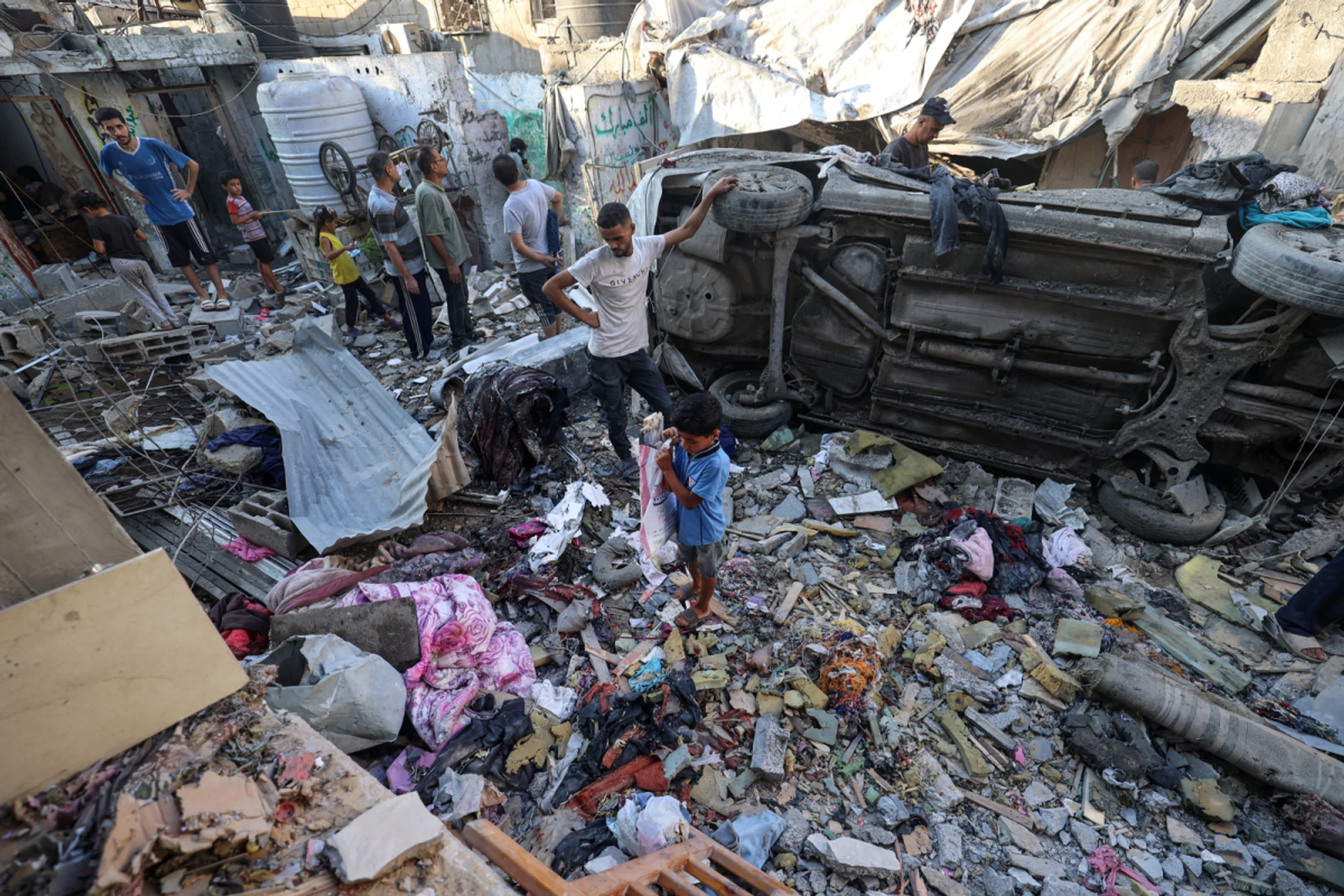 Bewohner im Gazastreifen vor den Trümmern ihres Hauses