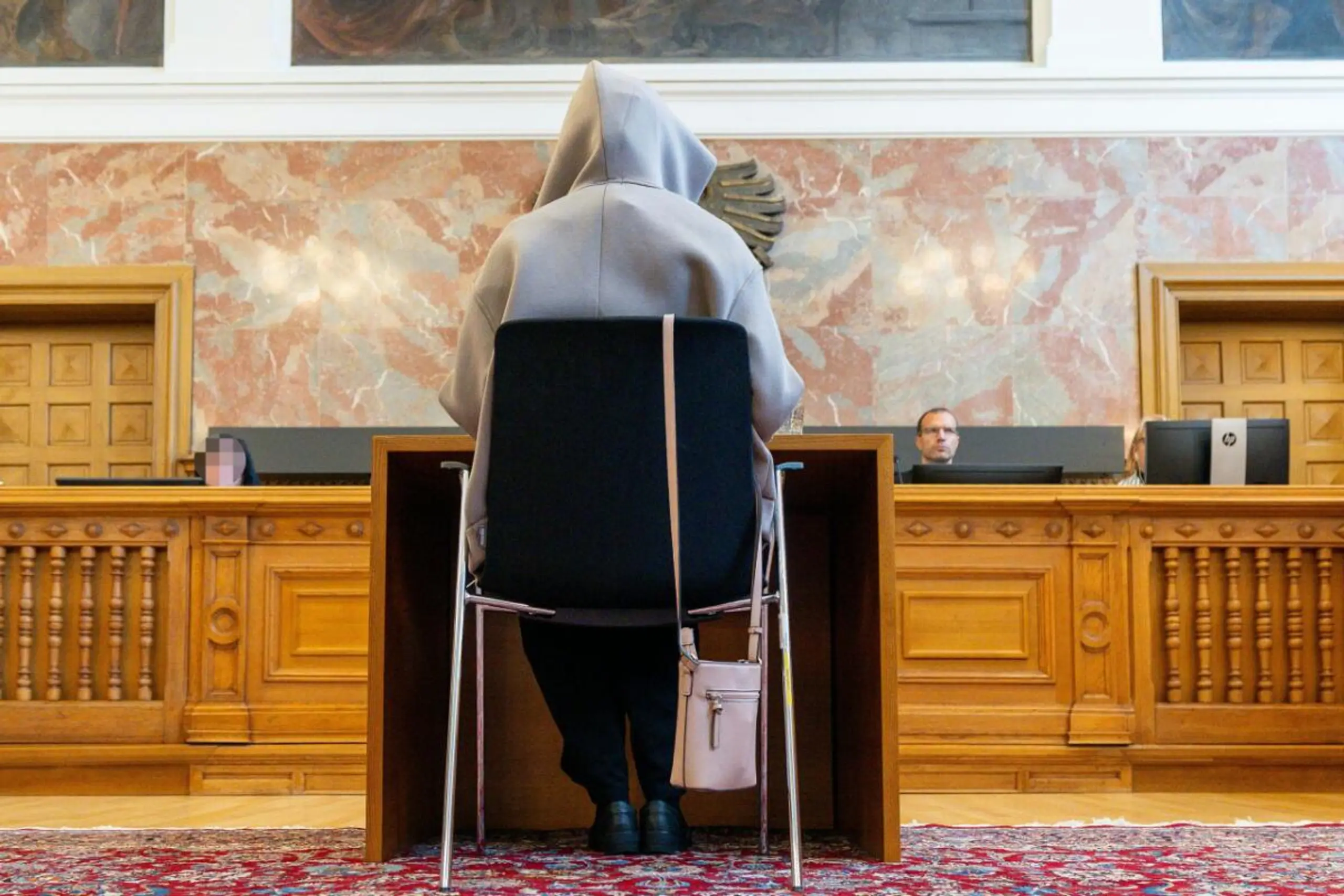 Eine Kapuze sollte die Angeklagte vor Fotografen schützen